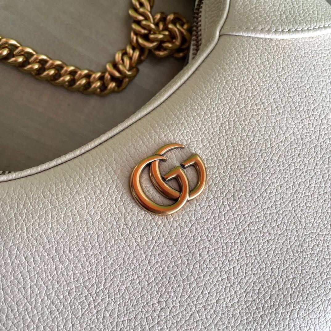 独家特级正品。G731817尺寸：25x19x7cm！Cosmogonie)系列在意大利历史悠久的蒙特城堡亮相。这一全新的新月造型小号肩背包从品牌典藏元素汲取灵感，采用柔软皮革材质呈现，并饰有在20世纪70年代亮相的双G标志🔥🔥 它配有两条可肩带 可调节肩带（55厘米高） 可拆卸链式肩带（26厘米高）