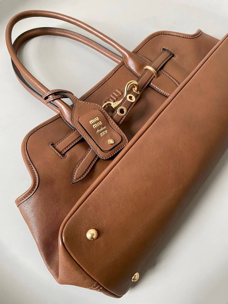 🈶焦糖色， 𝗠𝗶𝘂𝗠𝗶𝘂 手提包·横版 这只Aventure我要夸爆它！ 绝对是公文包中的颜值天花板 这款有多难买不用多说，绝对的断货王 酷酷的慵懒感洋气且时髦 还有一丢vintage感，超有调 上班通勤，日常出街都超出片 22.5×44×14.5cm #F0023m