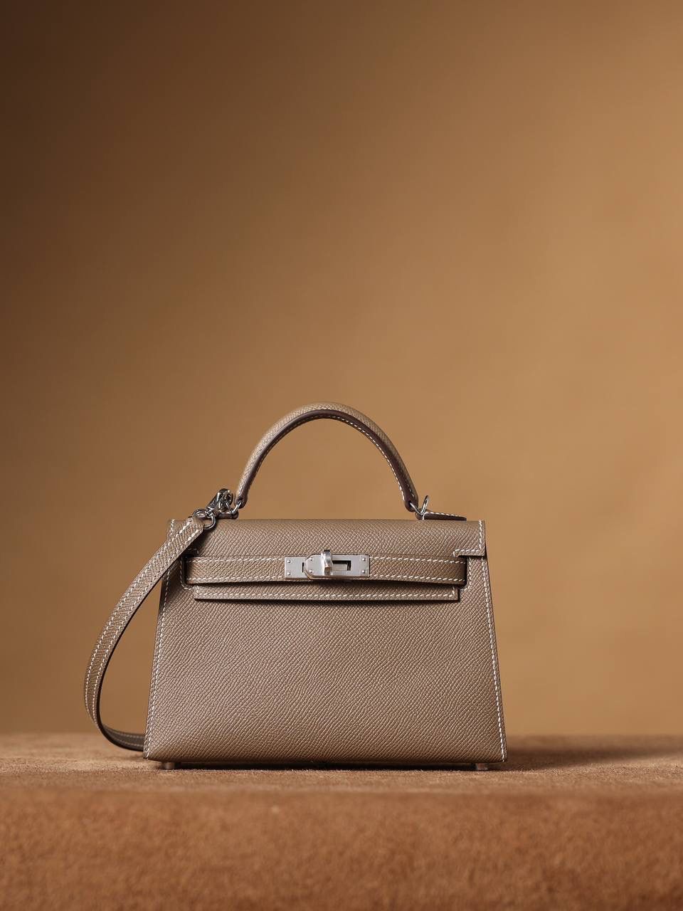 HERMES 爱马仕 Mini Kelly 二代 👜✨ Mini Kelly 二代 大象灰银扣 高清实拍图 尺寸：19*12*6cm Hermès爱马仕是世界著名的奢侈品品牌，1837年由Thierry Hermès创立于法国巴黎。爱马仕早年以制造高级马具起家，迄今已有180年的悠久历史。 其整个品牌从整体到细节以及专卖店，都弥漫着浓郁的以马文化为中心的深厚底蕴🎀