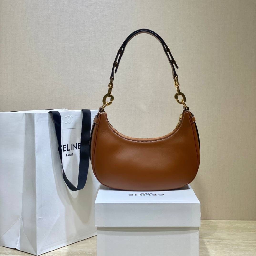 🔥大货实拍图 𝗖𝗘𝗟𝗜𝗡𝗘 ♥ 𝗔𝗩𝗔 𝗦𝗧𝗥𝗔𝗣 独特新月包型打造摩登格调，醒目金属圆环与考究皮革饰带点缀，匠心与巧思交织，定格别致意趣造型。型号：196923 尺寸：24*13*7cm