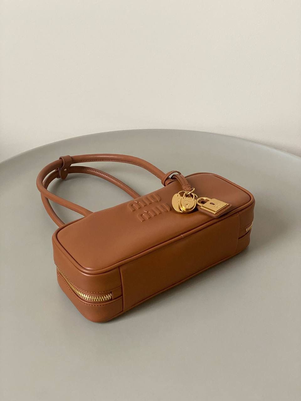 🈶干邑色 𝗠𝗶𝘂𝗠𝗶𝘂保龄球| 吊饰版 说是公文包.更是保龄球！ 虽倆者都早已大火全网时髦圈哈哈 今年这只长手柄保龄球能买到就是赚到咯！ 细长的手柄整体更秀气了 还送了一串吊饰 是一把锁头还有一个爱心， 上面都有logo刻印很精致也很厚重 宝子们再也不愁买挂饰啦！ 28×11.5×8cm #F0010m