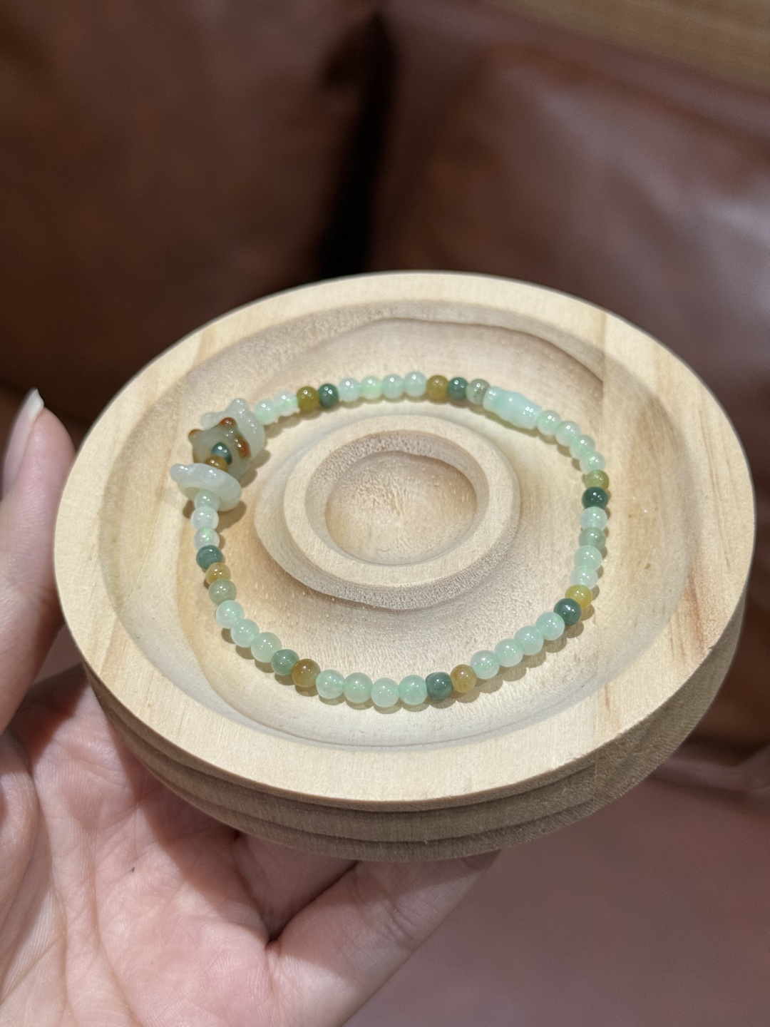A cat nestled in jade, a touch of playfulness, a touch of cuteness, surrounded by delicate beads—its movements, both still and dynamic