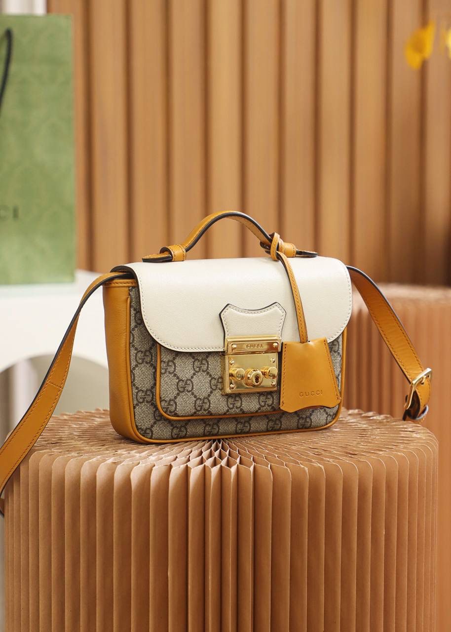 𝐩𝐚𝐝𝐥𝐨𝐜𝐤小锁扣邮差包#658487#正品皮 ✔️尺寸：21*14*5cm 𝐩𝐚𝐝𝐥𝐨𝐜𝐤新品锁头邮差包， 超赞的设计，拼色灵感源自典藏设计， 为邮差包造型再添惊艳之作， 经典的𝐩𝐚𝐝𝐥𝐨𝐜𝐤标志性小锁扣， 搭配全新的亮色拼接设计， 容量更加人性化的分层收纳， 让你日常使用更加便捷舒适！ 超级种草，又是一个大爆款的节奏！🔥🔥