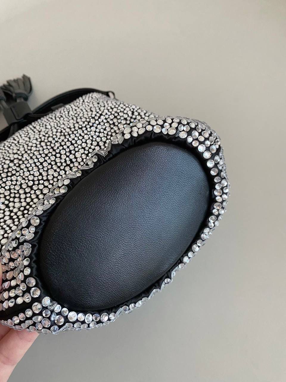 🈶钻石黑 𝗠𝗶𝘂𝗠𝗶𝘂满钻水桶包 blingbling的又是多少女生的心头爱 整个包身贴满水晶，搭配软绵绵的小羊皮， 在光线下非常闪✨不管是日常约会， 节日派对 晚宴都会是人群中的抢眼包 15×17×11cm F0053m