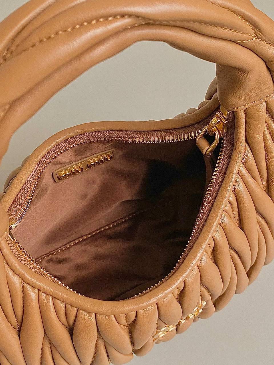 🈶焦糖小号 𝗠𝗶𝘂𝗠𝗶𝘂 𝗪𝗮𝗻𝗱𝗲𝗿 𝗛𝗼𝗯𝗼褶皱腋下 火爆全网都不用多说，人手一只的程度 我们用的是进口小羊皮！非国产皮料 肉眼可见的细腻，软软糯糯触感非常好！ 他家经典独特的褶皱工艺，是要有一定厚度 底料太薄了都做不出它的饱满和弹性 更不是市场通货干瘪瘪的褶皱，实在太假 我们新合作的老师傅在这细节上扣的很认真 一缕一折都有zp的神韵，且做到对版！！ 追求高品质的来 小号：17×20×6cm，#F0013m 中号：18x25x7cm