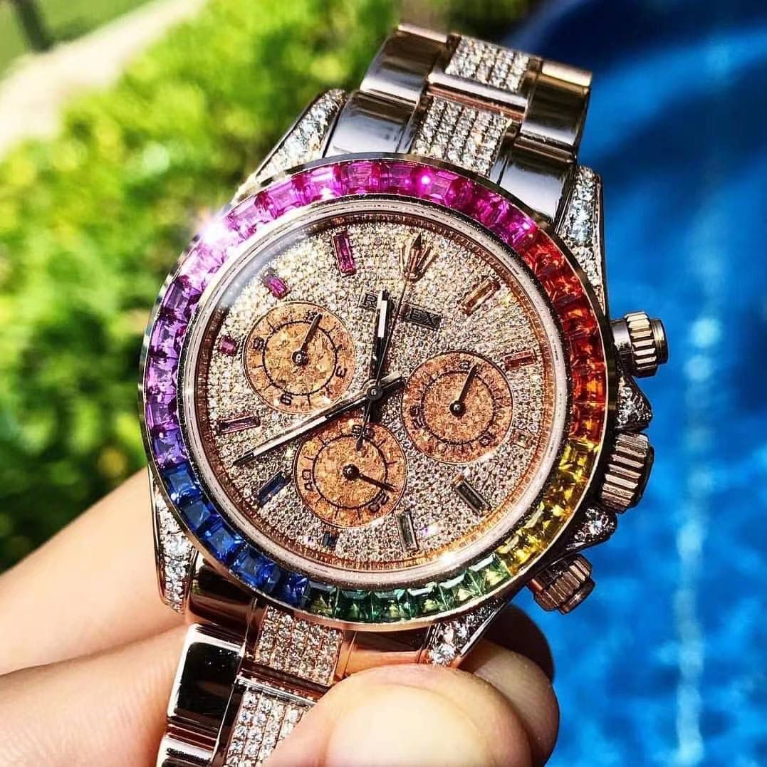 飞越彩虹之巅---劳家彩虹圈迪通拿 铂金眼 Cal.7750机械计时， “二代彩虹迪通拿”表壳、表带采用316L精钢材质打磨，每个壳套全程CNC处理所有细节，再经过人工流程润饰，打磨和检测做工精细，圈口角度与宝石大小数量颜色跟专柜彩虹渐变效果一致，玻璃使用蓝宝石透彻效果镜面，机芯采用7750全自动计时机械机芯，表带分别全人工镶钻精钢实心表带OR进口氟橡胶表带，配备防止意外打开的蚝式保险扣，佩戴舒适，操作也十分简便！ 这款腕表最大的特点莫过于表圈的七彩宝石和字面的十二个彩钻刻度，彩色渐变效果一一对应，这些宝石闪耀着红橙黄绿青蓝紫等斑斓的色彩，恰似添上曼妙多姿的变化色彩，劳力士精心挑选了玲珑精巧的宝石，并组合镶嵌在了一起，为腕表赋予了奇异的光彩。