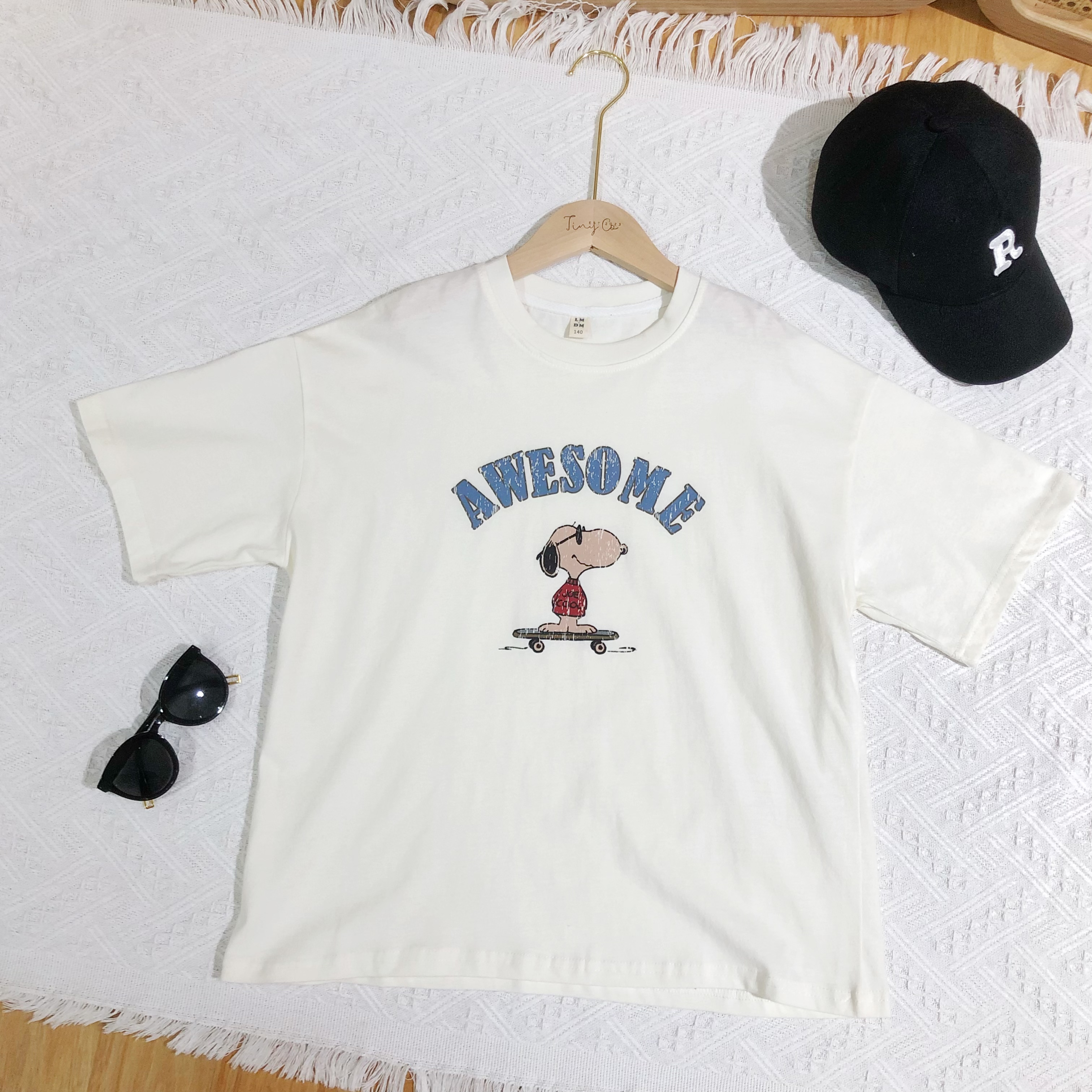 Here are a few possible product titles for the image:**Short & Sweet:***   Snoopy T-Shirts*   Graphic T-Shirts**More Descriptive:***   Snoopy Let's Do Lunch Graphic Tee and Snoopy Awesome Skateboard Tee*   Vintage Snoopy T-Shirt Collection*   Snoopy Character T-Shirt Set**Catchy/Trendy:***   Snoopy Chill Vibes Tee Collection*   Snoopy Retro Cartoon Graphic T-Shirt 