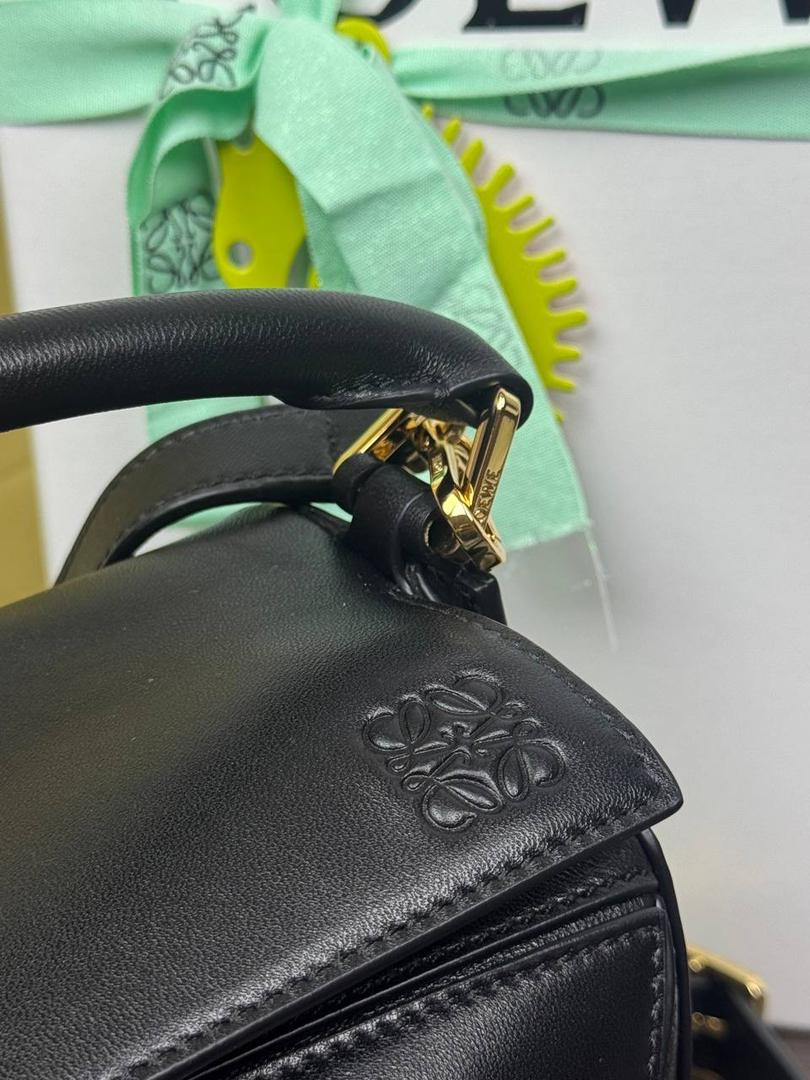 🎈【周年限定】 小号纳帕羊皮𝗙𝗲𝗮𝘁𝗵𝗲𝗿𝗹𝗶𝗴𝗵𝘁 𝗣𝘂𝘇𝘇𝗹𝗲手袋👜 ——黑色到货❤️ 尺寸：𝟮𝟰-𝟭𝟬.𝟱-𝟭𝟲.𝟱𝗰𝗺 编码：061610【配全套礼盒】 ✅延续经典老款𝗣𝘂𝘇𝘇𝗹𝗲做法，全新𝗣𝘂𝘇𝘇𝗹𝗲内外采用柔软轻盈的纳帕羊皮材质，为手袋注入随性慵懒的风格。 ✅该款饰有旋转卡扣，铰链式拉链头，一个外部拉链后袋，一个内部插袋，以及可拆卸式的𝗟𝗢𝗘𝗪𝗘烫金或烫银标签，饰有隐秘口袋和气球骰子，底部长方形金属脚钉。搭配可拆卸可调节长肩带，可肩背、斜挎或手提。