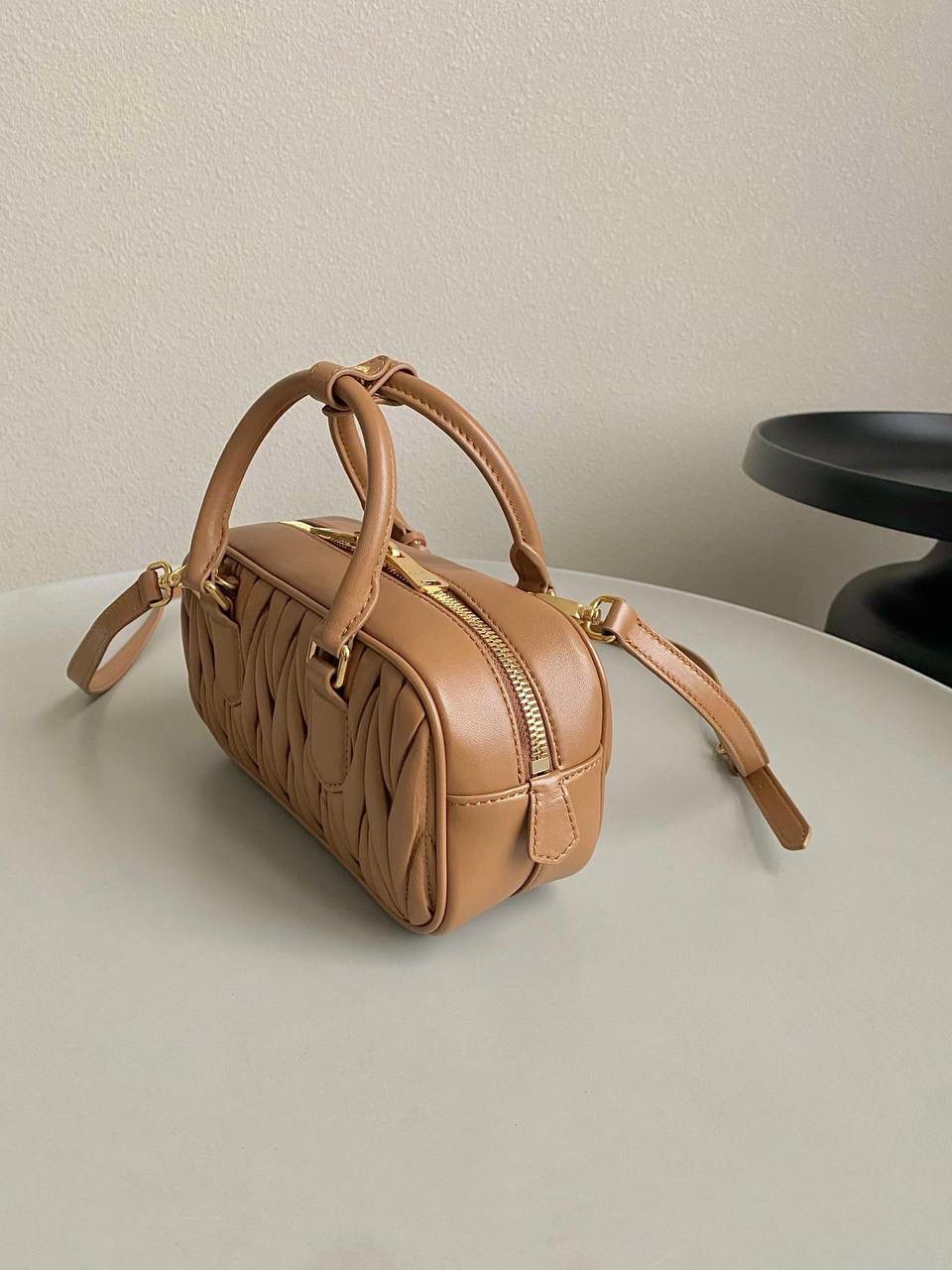 🈶焦糖小号 𝗠𝗶𝘂𝗠𝗶𝘂褶皱保龄球 火爆全网都不用多说，人手一只的程度 我们用的是进口小羊皮！非国产皮料 肉眼可见的细腻，软软糯糯触感非常好！他家经典独特的褶皱工艺，是要有一定厚度 底料太薄了都做不出它的饱满和弹性 更不是市场通货干瘪瘪的褶皱，实在太假 我们新合作的老师傅在这细节上扣的很认真 一缕一折都有zp的神韵，且做到对版！！ 追求高品质的来🔥⚡️ 小号：22×10.5×7.5cm，#F0011m 大号：27x12x9cm