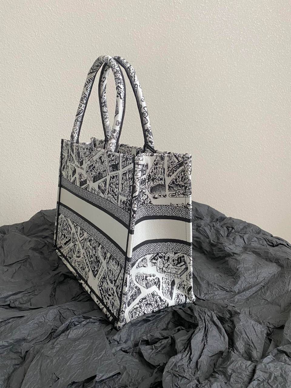 🈶白色中号 𝗖𝗗 𝗕𝗼𝗼𝗸 𝗧𝗼𝘁𝗲 23夏季"巴黎地图" 说实话，近年来花卉系列有点看乏看腻的 请你们一定看看这一只，新的炙热款！！ 本季主打的巴黎第八街区地图，惊艳了全网 真真实实绣在整个包上，砖柜超级难抢的！ 黑白色调干净利落，复古又神秘的法式浪漫✨ 那种高定视觉，沦陷了！沦陷了！ 行走的巴黎街头很是时髦，我先冲了！🎀 36×27×16cm