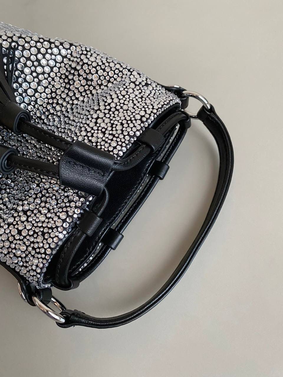 🈶钻石黑 𝗠𝗶𝘂𝗠𝗶𝘂满钻水桶包 blingbling的又是多少女生的心头爱 整个包身贴满水晶，搭配软绵绵的小羊皮， 在光线下非常闪✨不管是日常约会， 节日派对 晚宴都会是人群中的抢眼包 15×17×11cm F0053m