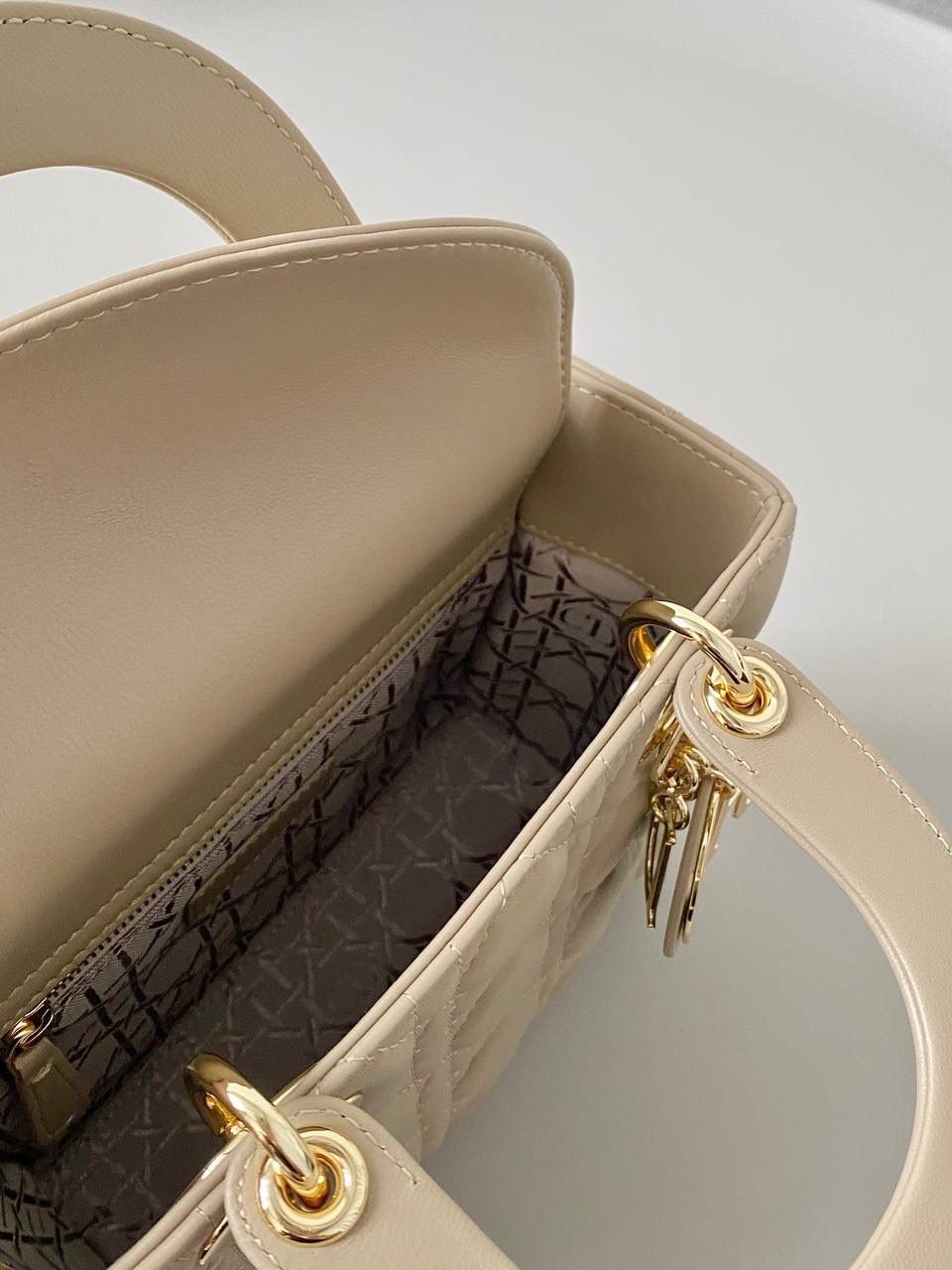 🈶奶茶色 𝗗𝗜𝗢𝗥 𝗟𝗮𝗱𝘆羊皮四格金扣 谁能拒绝这只刚出的新颜色啊 救命，真的太温柔了！很显气质 淡淡的色调，看着心情就很好 比去年的奶茶色要深，偏灰调些 进口原厂羊皮➕全钢五金，最高版本 （配6个五金图案 全套包装） size：20×16.5×8cm 4123m