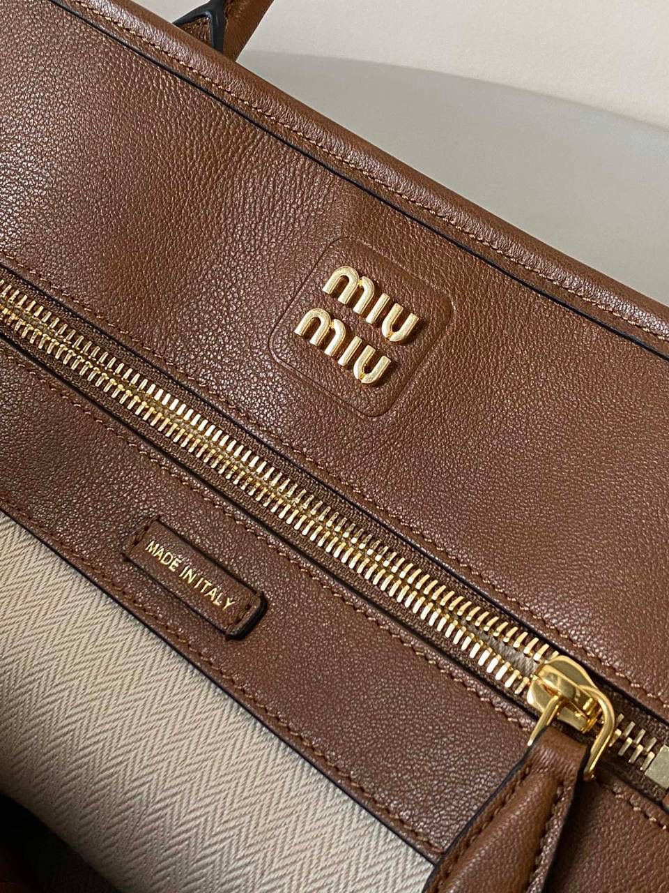 🈶焦糖色， 𝗠𝗶𝘂𝗠𝗶𝘂 手提包 这只Aventure我要夸爆它！ 绝对是公文包中的颜值天花板 这款有多难买不用多说，绝对的断货王 酷酷的慵懒感洋气且时髦 还有一丢vintage感，超有调 上班通勤，日常出街都超出片 很有年轻人的活力！ 31×40×13cm #F0023m