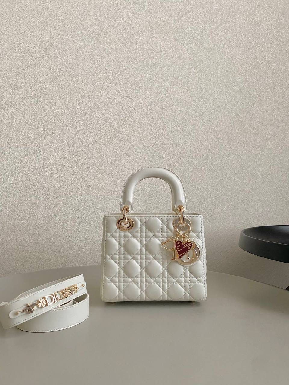 🈶白色，四格 𝗗𝗜𝗢𝗥 𝗟𝗮𝗱𝘆七夕限定 在经典的基础上加了爱心小挂饰 让整个氛围有了爱的烂漫气息 戴妃作为经典的代表，怎么买怎么对 特别手拎时会显得整个人非常温柔优雅 我一直都推荐女生一定要有一只经典款 每个颜色都好好看，完全不需太纠结 20×16.5×8cm 4123m