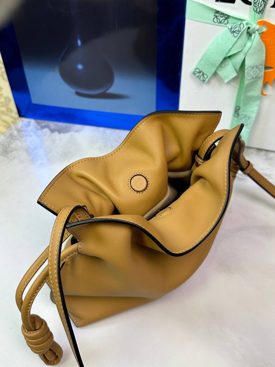 Flamenco clutch ✦迷你✦ 尺寸：𝟐𝟐.𝟓-𝟏𝟖-𝟗𝐜𝐦 型号：052030 棕色 ❤️mini flamenco clutch bag 可手拿亦可优雅斜挎 云朵般温暖亦轻盈的造型如此简单，💯耐看💯不会out的款式！ ❤️包袋采用进口小牛皮，手感如羊皮般细腻柔软，却比羊皮更加结实耐用，麂皮内衬 ❤️品牌标志性绳结设计，收紧袋口就是小福袋造型，超Q，看着不大实际超会装😇