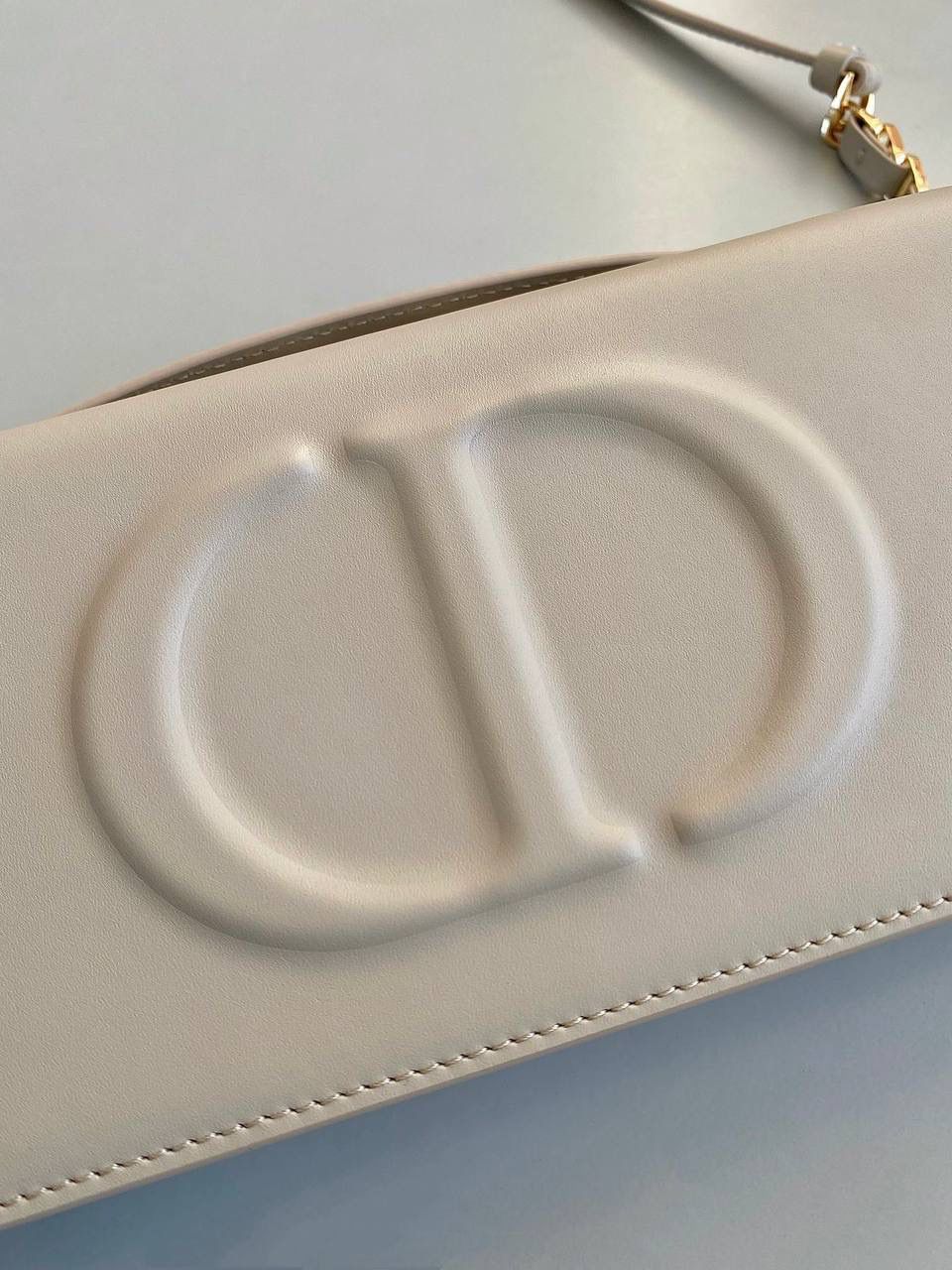 🈶全皮米色 𝗗𝗜𝗢𝗥 𝗦𝗶𝗴𝗻𝗮𝘁𝘂𝗿𝗲 链条手袋 全新系列一出直接萌翻天，很难不火 通常在金属包扣或链条装饰的CD字母 这次当了回主角，直接放大像极了猪鼻子 压印浮雕质感和字母的立体弧度，好高级 成了包身上一眼就能看到的重点元素 女生风格多面，包包更是如此 当一只小可爱不仅可以斜挎单肩 还能拎着当手拿包，搭配丝巾腋下背 基本就已经被拿捏住了！！ 翻盖开合像个小盒子，日常通勤容量OK 21×11×5cm，#8133m