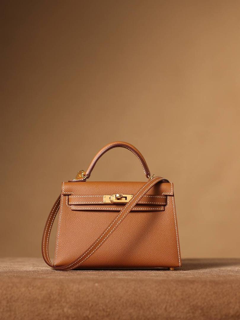 HERMES 爱马仕 Mini Kelly 二代👜✨ Mini Kelly 二代 金棕金扣 高清实拍图 尺寸：19*12*6cm Hermès爱马仕是世界著名的奢侈品品牌，1837年由Thierry Hermès创立于法国巴黎。 爱马仕早年以制造高级马具起家，迄今已有180年的悠久历史。 其整个品牌从整体到细节以及专卖店，都弥漫着浓郁的以马文化为中心的深厚底蕴🎀