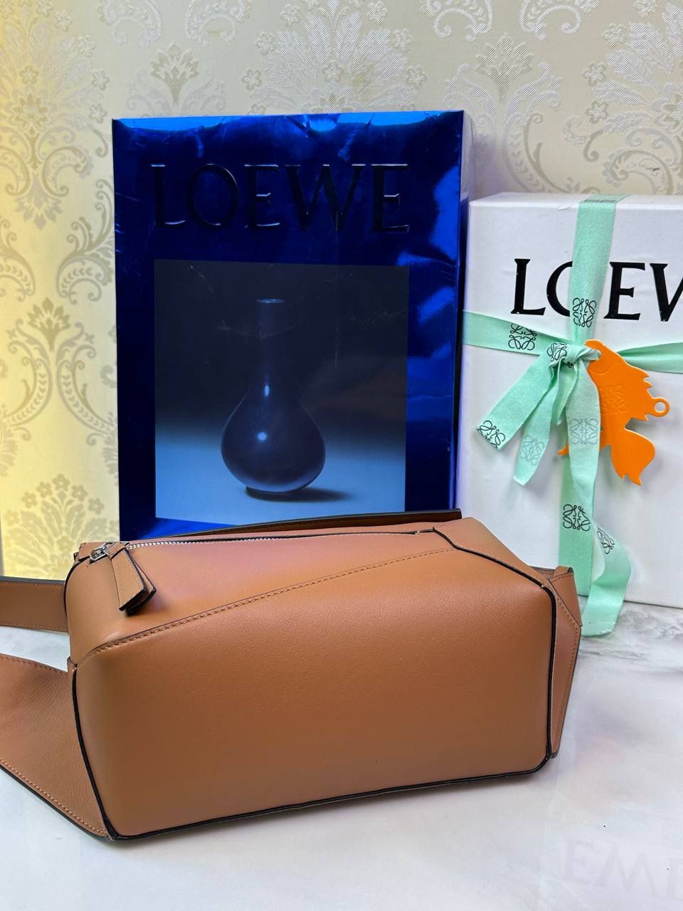 ⭐️最新升级版𝟮.𝟬-𝗣𝘂𝘇𝘇𝗹𝗲腰包⭐️ （土黄到货‼️） 尺寸：𝟮𝟰-𝟭𝟬.𝟱-𝟭𝟲𝗰𝗺 款号：052343 👉🏻长方体形状和精确的切割技巧创造出Puzzle 腰包以及独特的几何线条成为 “Loe罗家”的著名代表作~ 👉🏻金属搭扣开合，刻有标志logo徽标，可调节肩带，翻盖大容量插袋和一个外部拉链口袋，🐂柔软细腻napa小牛皮，正品Ykk五金，Anagram压纹，人字纹棉麻帆布内里 👉🏻（男女♀♂同款）大小非常合适。胸包、背包、单肩、斜挎、腰包五种背法任你解锁🔒 👉🏻 （独家背景➕独家品质➕独家包装➕独家控制对版细节📦➕精致全套礼盒套装❤️） 重点：让你花最少的钱💰体验最大的仪式感❤️