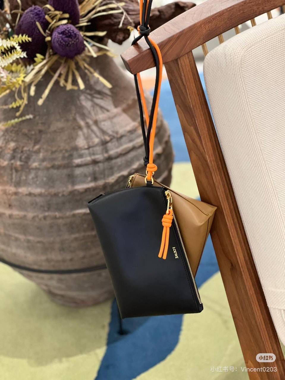 🎈𝘒𝘯𝘰𝘵 𝘛手拿包👜 —【黑色/耀眼橙到货✅】 编码：522414 尺寸：𝟐𝟐.𝟓-𝟓.𝟓-𝟏𝟓.𝟓𝐜𝐦 全新撞色绳结拉链头和腕带设计，顶部拉链开合，内部人字纹帆布衬里以及2个皮隔层卡位，正面饰以品牌标志性烫金𝗟𝗼𝗴𝗼，方便时尚多用。