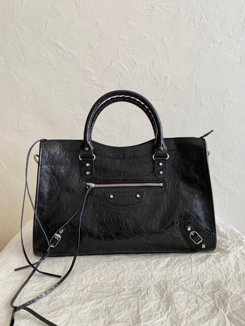 爆款🔥再次回货❗️ ba1enciaga lie city机车包中号 黑银🖤 24款比中古款有几处变化 肩带变得更干净利落，不累赘 底部的铆钉也去了，也是可以给包身减重 拉牌也全都换成了流苏～显得更流浪不羁了 机车包最有灵魂的就是它的皮料 皮纹够丰富，皮质够柔韧 一定要用原厂皮才能做出最高的还原度 认准我们家，只做原厂皮⚠️ 38.5×24×13.5cm797786m