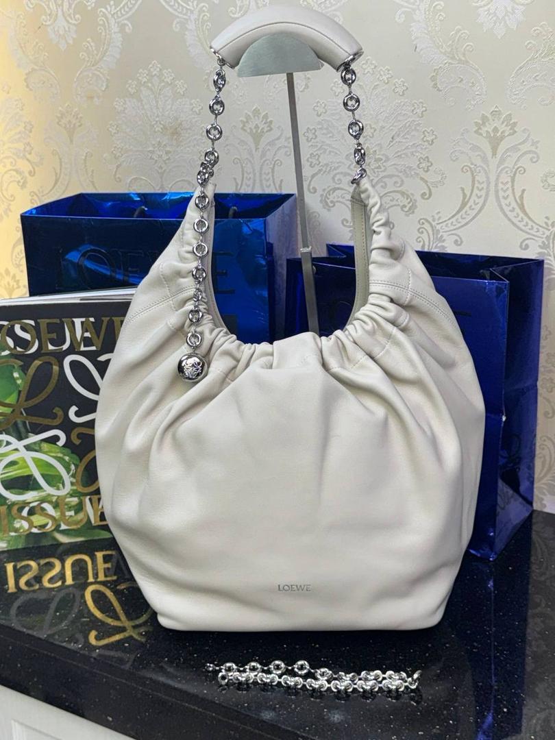 🎈（全钢五金）中号纳帕羊皮𝙎𝙦𝙪𝙚𝙚𝙯𝐞 —【海盐白】到货📍 尺寸中号：34-33-13.5cm 尺寸小号：29-10.5-24cm 型号:652328 【配全套礼盒】 😇罗家全新成员Squeeze手袋💯 满分到货•采用触感柔软的纳帕小羊皮革🐏•里外全皮💯传统工艺➕创新研究•全新独特设计。 😇最新宣言款配件：Anagramc pebbled 不锈钢及铝合金材质•升级打造标志性甜甜圈•相同质感•更轻重量。 😇具备令人惊讶的轻盈褶皱包身 可肩背、斜挎或手提*可调节甜甜圈⛓️链条肩带•搭配Anagram携刻鹅卵石•附加额外链条•可进一步延长肩带*磁扣开合*内部拉链口袋