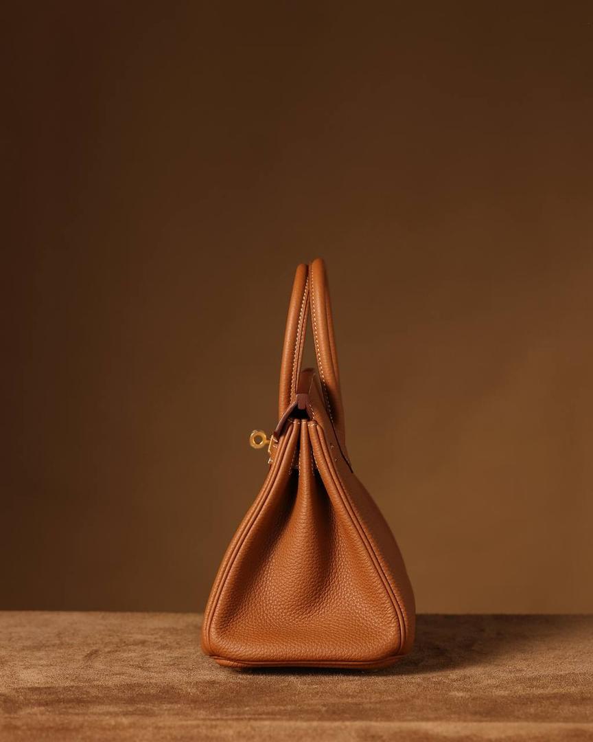 Hermes 爱马仕 Birkin25cm 金棕金扣👜✨ Birkin 独家渠道货 独家欧洲原厂皮原厂五金组装的ZP尾单货 尺寸：20 X 25 X 13CM 尺寸：22 X 30 X 16CM Birkin我们采用的是进口原厂Togo真皮，什么是Togo皮呢？ Togo皮：最经典的Birkin用皮。表面是均匀的颗粒状，类似荔枝纹，有光泽。皮质较硬，容易保持包包的形状，相对较轻，触感比较柔软，耐磨耐用； 我们用的是纯原、原厂皮就是和原版专柜一样的皮！