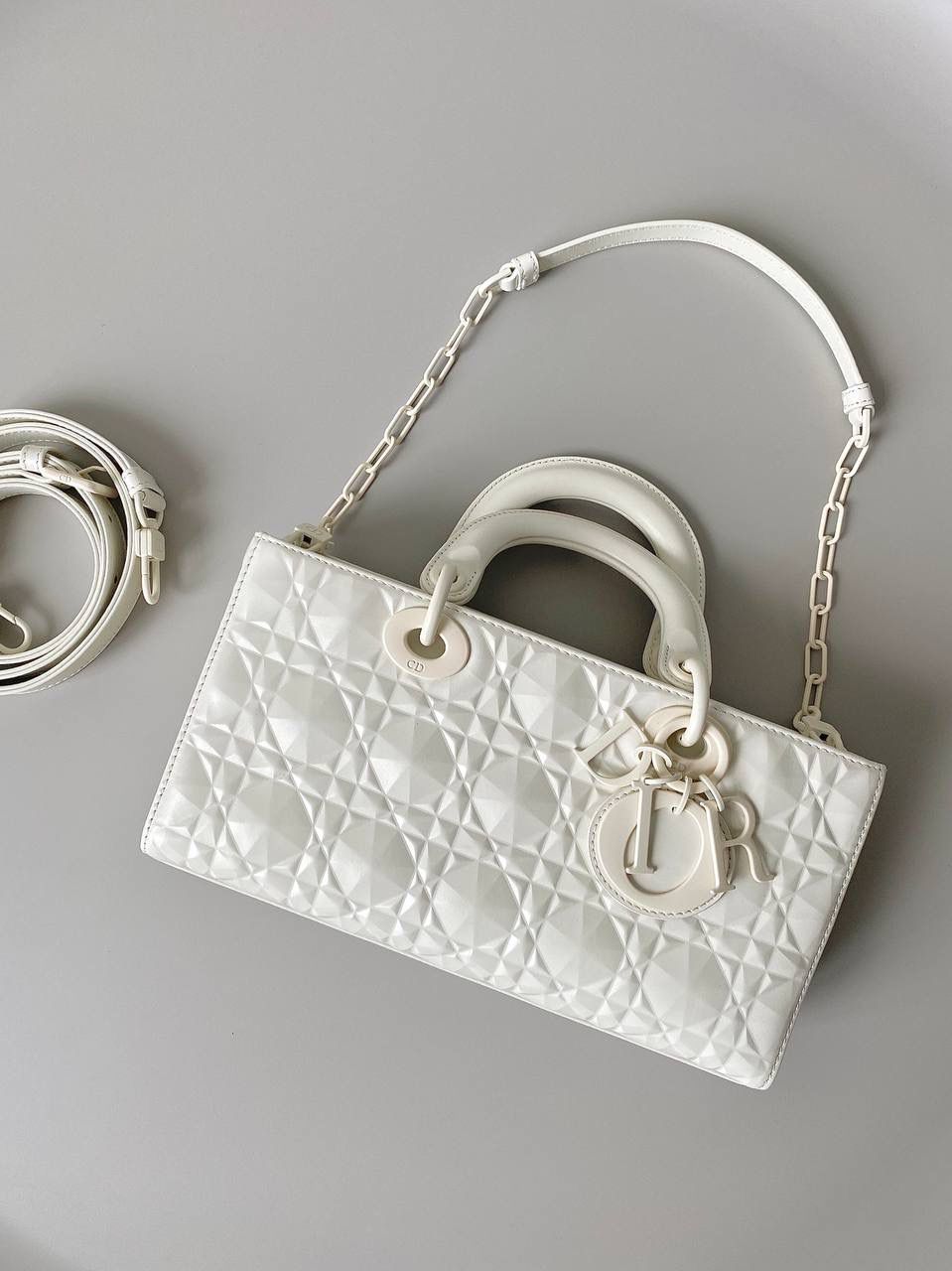 钻石白🎀𝗗𝗶𝗼𝗿 𝗗-𝗝𝗼𝘆 𝗯𝗮𝗴 时尚果然就是轮回，回归了一把中古戴妃 特殊处理的哑光牛皮钻石藤格纹，八个切割面挺括有型，全套磨砂材质五金，长方包形短链条➕细长肩带直接封神！！ 复古时髦感超强，真是什么场合都可以把住 绝对是lady中的天花板了，强势出圈啦姐妹们😎✨ 26 x 13.5 x 5cm