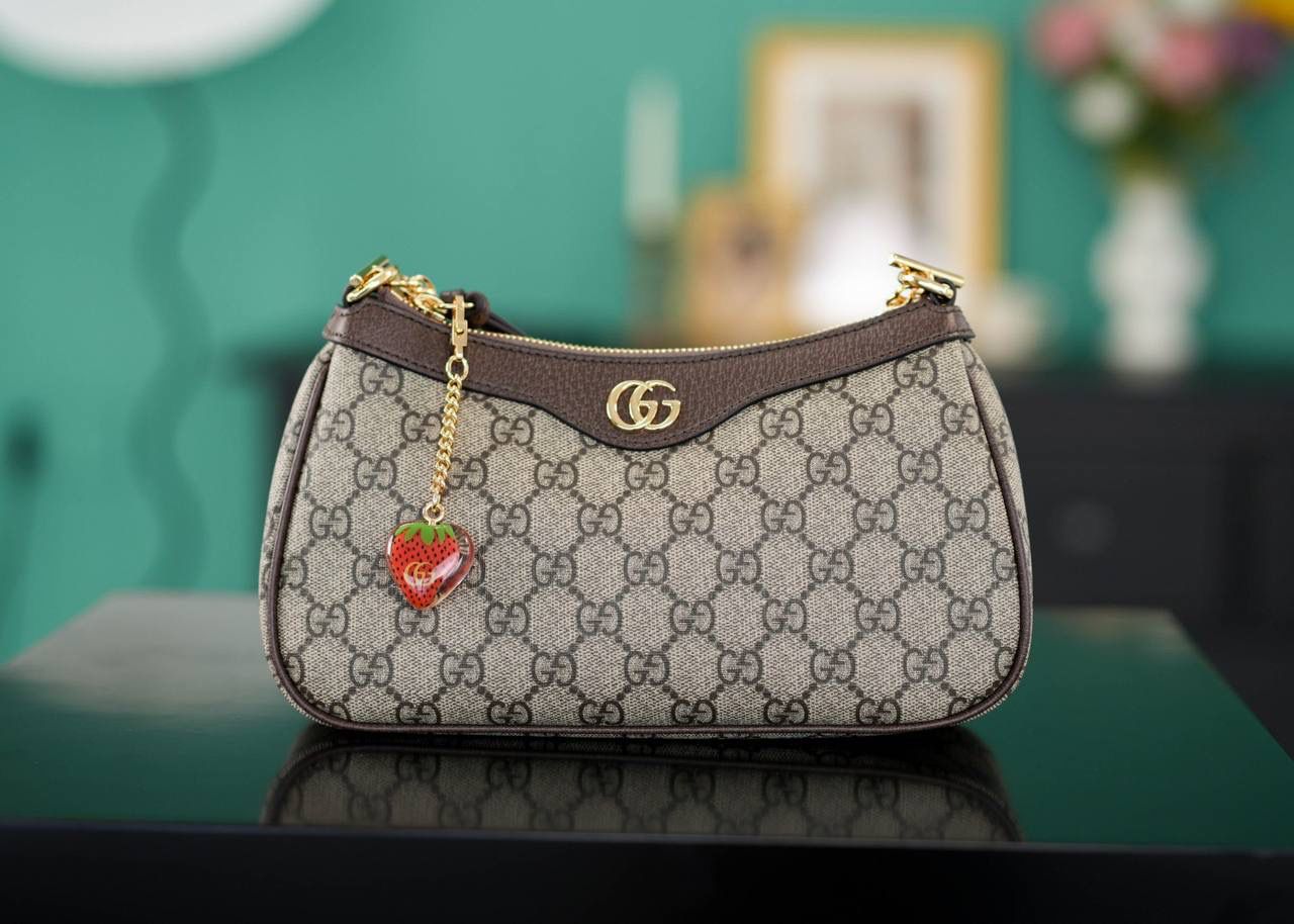 🥯Ophidia系列小号手袋 草莓包棕色 25cm 这款草莓包惊喜感非常强， 经典的元素搭配小巧可爱精致时髦挂饰， 金属链条和经典红绿织带，复古感十足且百搭， 可爱又别致的小草莓是点睛之笔， 整个包包很轻便，特别好背呢~ 官方款号 735132 尺寸：25x15x6cm