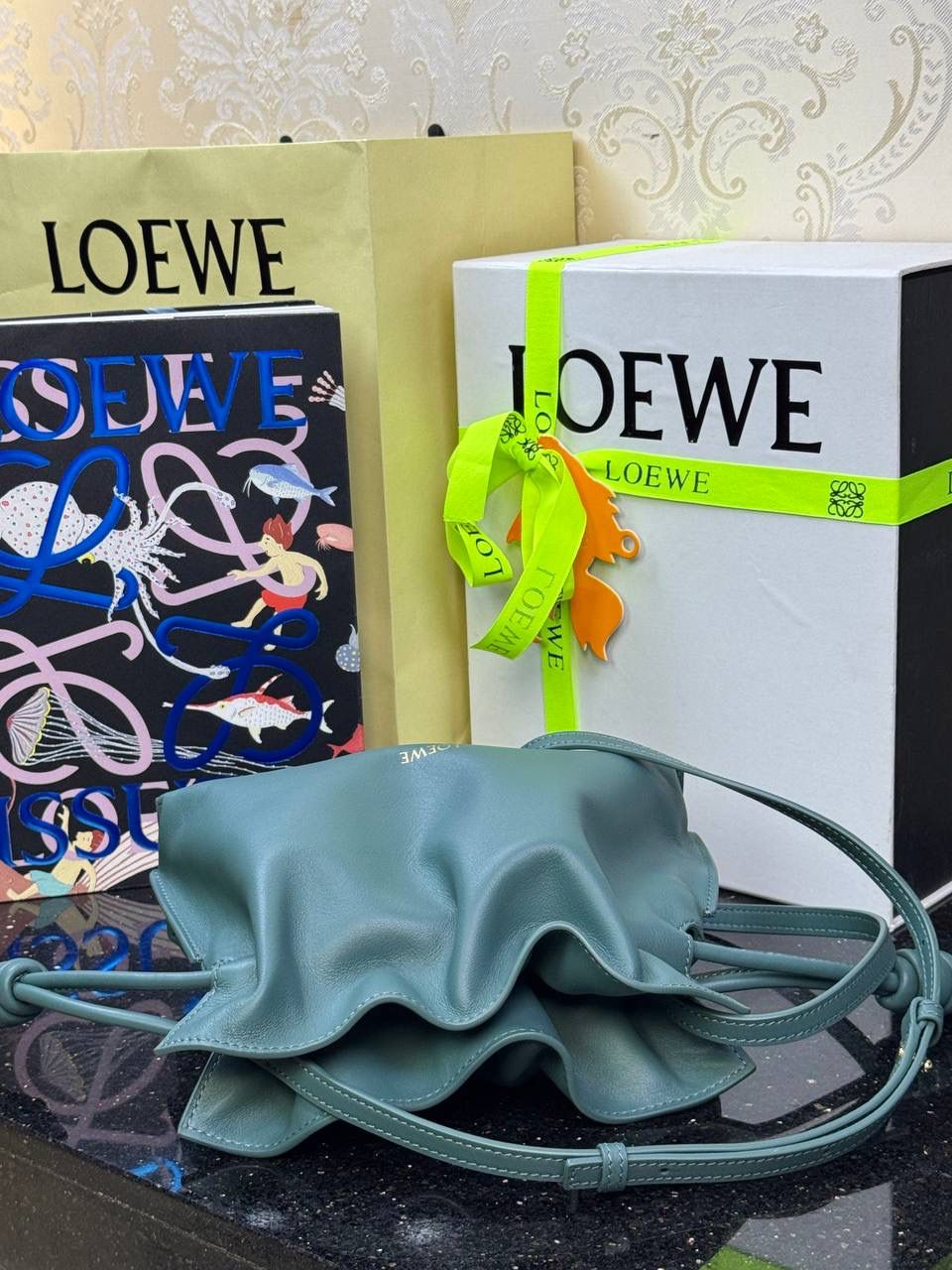 🎈全新升级—迷你烫金款𝙁𝙡𝙖𝙢𝙚𝙣𝙘𝙤出货啦✅ ❤️升级版福袋正面新增品牌烫金𝙇𝙤𝙜𝙤代替压印𝙇𝙤𝙜𝙤，肩带加宽同时增加两侧狗扣五金代替原本皮穿扣肩带，精致又便捷🥰 ❤️独家定制皮料五金，小牛皮皮质手感十分柔软且耐用，肩带🉑拆卸🉑调节，多种背法任你选择，容量超大，日常出行必备😍 ❤️独家品控，完全对版细节，全套礼盒🎁包装给你满满的仪式感🥰 迷你尺寸：𝟐𝟑 𝟗-𝟏𝟖-𝟗𝐜𝐦 款号：052030香根草绿