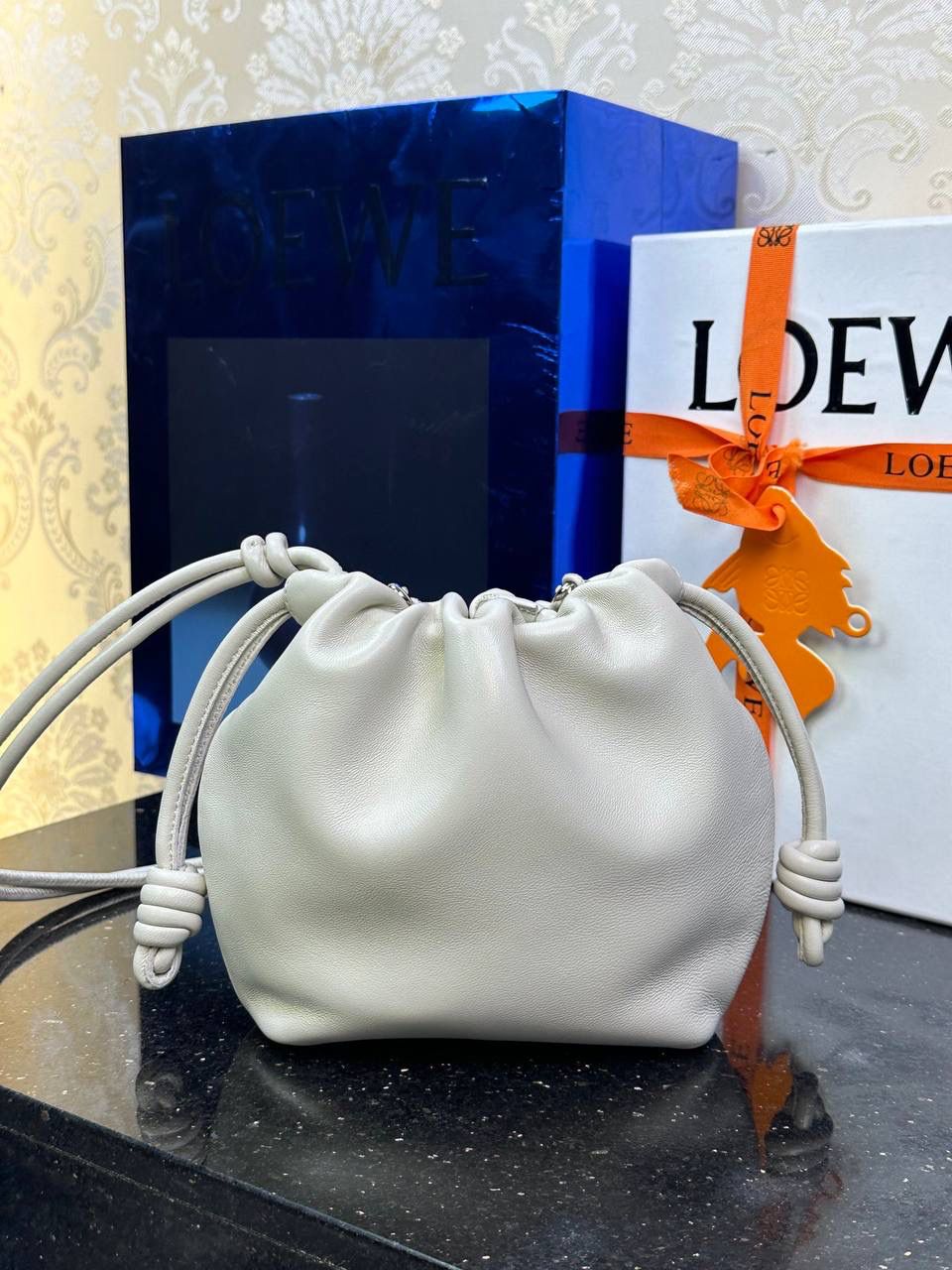 🎈迷你链条款𝙁𝙡𝙖𝙢𝙚𝙣𝙘𝙤 𝙋𝙪𝙧𝙨𝙚羊皮 ——【海盐白】 尺寸：𝟐𝟑.𝟓-𝟓-𝟏𝟕𝐜𝐦 编码：062347 👉🏻延续福袋收缩绳褶皱设计，羊皮包身手感细腻柔软❤️ 👉🏻链条肩带➕皮肩带的双肩带设计，时尚百搭，给足了集美们多样化的选择。肩带可拆卸可调节，磁扣开合，正面烫金𝙇𝙤𝙜𝙤，呈现出高贵典雅的视觉感😍 👉🏻独家背景➕独家品质➕独家全套砖柜礼盒套装，市场高端品质皆在我手✌🏻