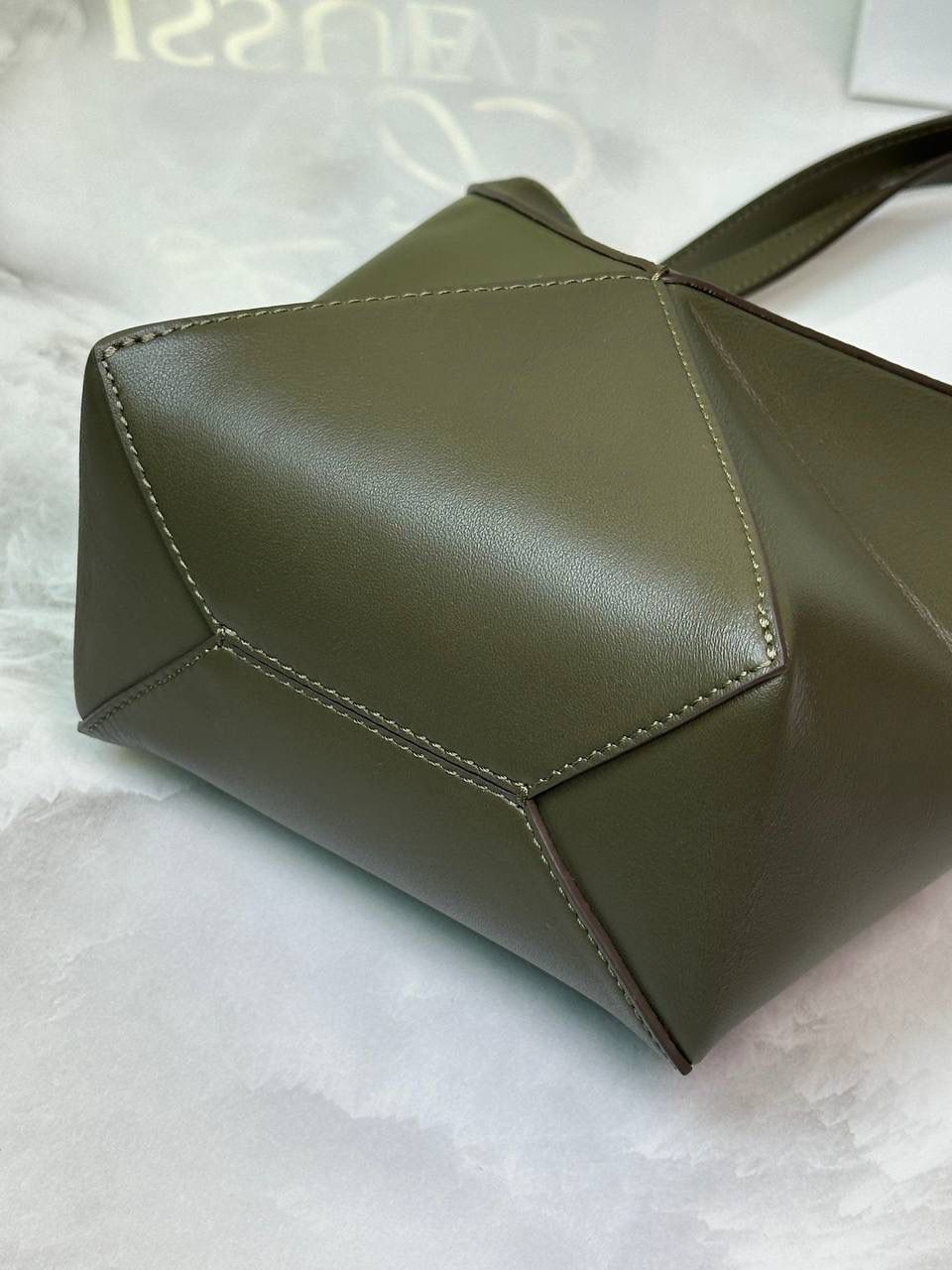 *𝐏𝐮𝐳𝐳𝐥𝐞 𝐅𝐨𝐥𝐝折叠手袋👜* ——全新【𝗡𝗘𝗪】升级‼️ 延续经典𝙋𝙪𝙯𝙯𝙡𝙚的标志性几何裁剪设计，新晋顶流🅰️𝙋𝙪𝙯𝙯𝙡𝙚 𝙁𝙤𝙡𝙚 𝙏𝙤𝙩𝙚以折纸包为灵感，升级成🉑完全折叠‼️的结构，立体与平面任意切换，出差旅行🧳必备单品。小牛皮材质轻且柔软，𝐌𝐢𝐧𝐢尺寸搭配一条可拆卸式肩带，手提，肩背，斜挎多样化背法✨ 尺寸：𝟏𝟔.𝟓-𝟗.𝟓-𝟐𝟎cm 款号：052322