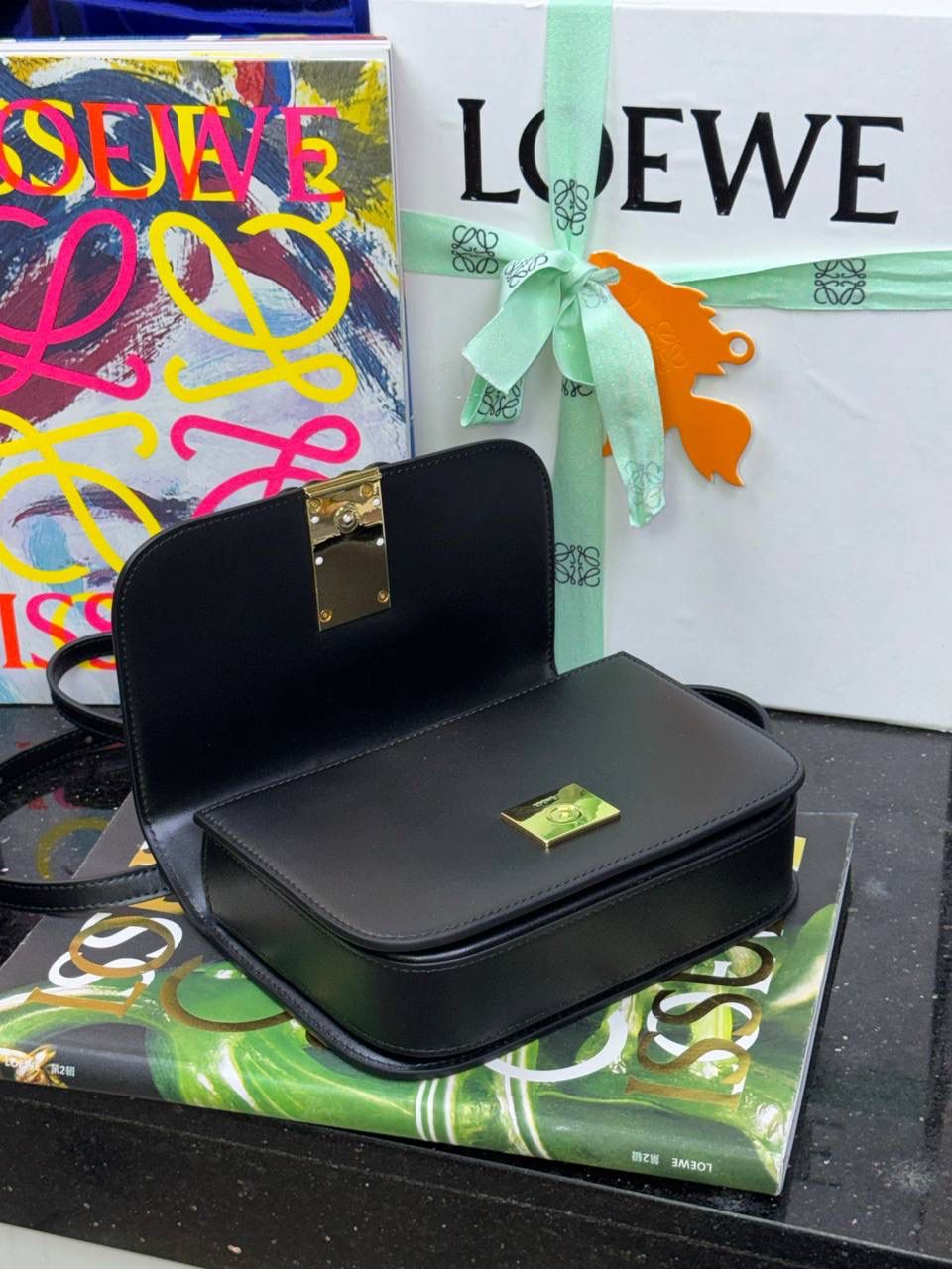 🎈单色釉𝘎𝘰𝘺𝘢*缎面皮 —【黑色到货✅】 尺寸：𝟏𝟗-𝟔-𝟏𝟑.𝟓𝐜𝐦 编码：262123 【配全套礼盒】 ✅汲取古代单色釉瓷器色彩灵感，全新打造𝘓𝘰𝘸𝘦*单色釉系列。该款采用缎面丝绸牛皮搭配内里纳帕羊皮，手感丝滑细腻。正面立体膨胀𝘈𝘯𝘨𝘳𝘢𝘮 𝘓𝘰𝘨𝘰设计搭配陶瓷小兔子挂饰，堪称时尚界的艺术品。 ✅磁扣开合，内部3个隔层设计，以及按扣和背面小侧袋，收纳方便➕安全感满分，能装，好搭。