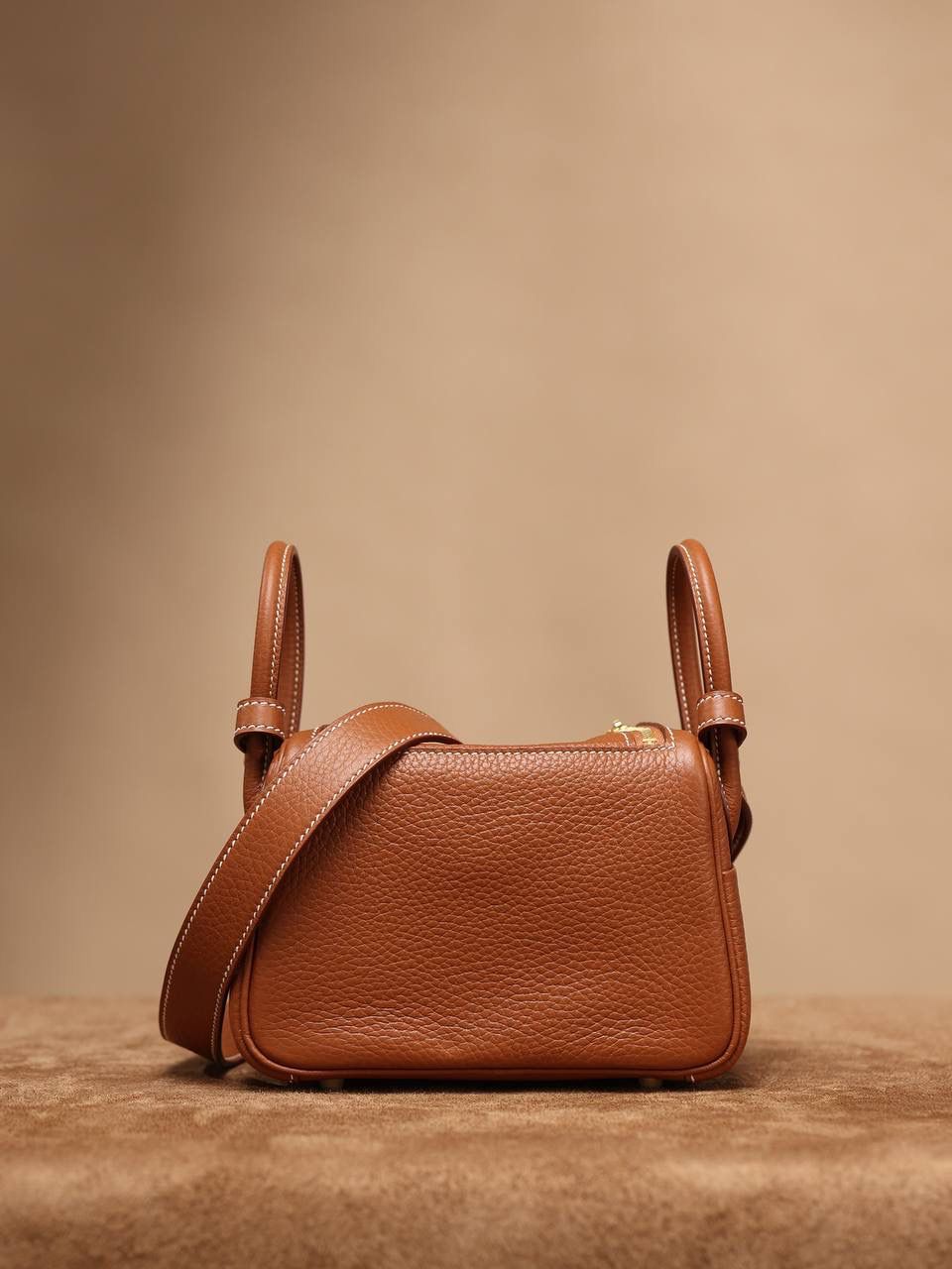 Hermes 爱马仕 Lindy Mini 19cm 金棕色金扣👜✨ Lindy 独家渠道货 独家欧洲原厂皮原厂五金组装的ZP尾单货 尺寸：19*12.5*9cm Lindy是采用原厂的正品TC皮，什么是TC皮？ 爱马仕专用的clemence,简称tc皮，是Hermes最受欢迎的皮革之一，颜色会比Togo少一些，但是纹路比Togo细腻，含油更高，更软，因此稍稍有些下垂感的特点。