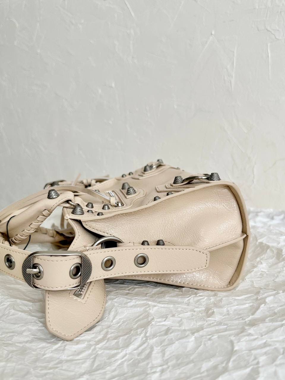 neo cagole 机车包xs奶茶色🥟 首先声明，我爱一切机车元素 无论是le cagole还是这只neo 喜欢大容量的姐妹冲这只 油蜡皮的不规则摔纹配上大量的五金配件 还有流苏拉牌➕爱心镜子➕零钱包挂件 极繁的魅力由此而来～ 辣妹酷妹冲冲！ 26×17.8×11.4cm700940m