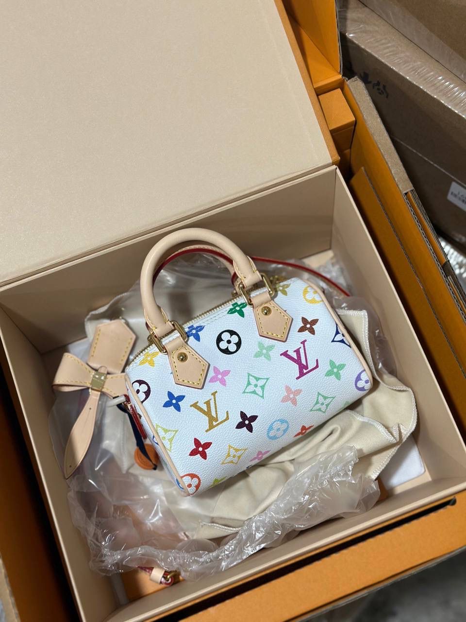 LV村上隆联名白三彩Nano Speedy来啦！姐妹们快看这个神仙包包！👜🌈 白色打底+彩色老花图案，配上祖传小锁头钥匙包，简直是《Mean Girls》千禧辣妹的标配！全新数码印花绝绝子，太阳花和熊猫都像要跳出来，阳光下自带ins滤镜特效！别看它巴掌大，手机口红💄钥匙全塞得下，从此打脸那些说mini包不实用的人！ 尺寸：16-10-7.5cm