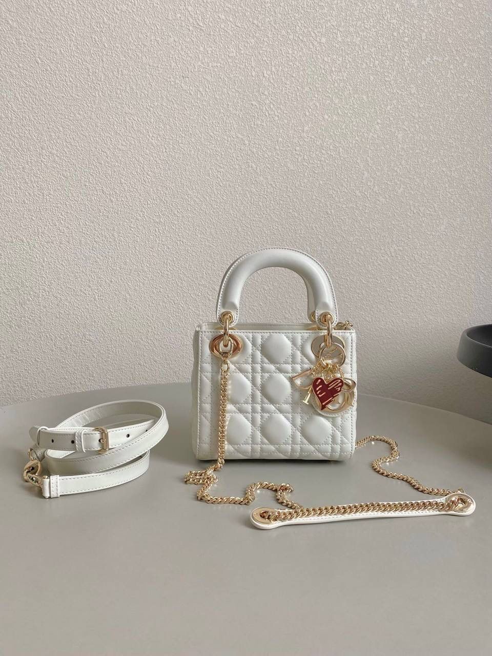 白色🌟 三格 𝗗𝗜𝗢𝗥 𝗟𝗮𝗱𝘆七夕限定 在经典的基础上加了爱心小挂饰 让整个氛围有了爱的烂漫气息 戴妃作为经典的代表，怎么买怎么对 特别手拎时会显得整个人非常温柔优雅 我一直都推荐女生一定要有一只经典款！！ 每个颜色都好好看，完全不需太纠结😍💓 17×15×7cm