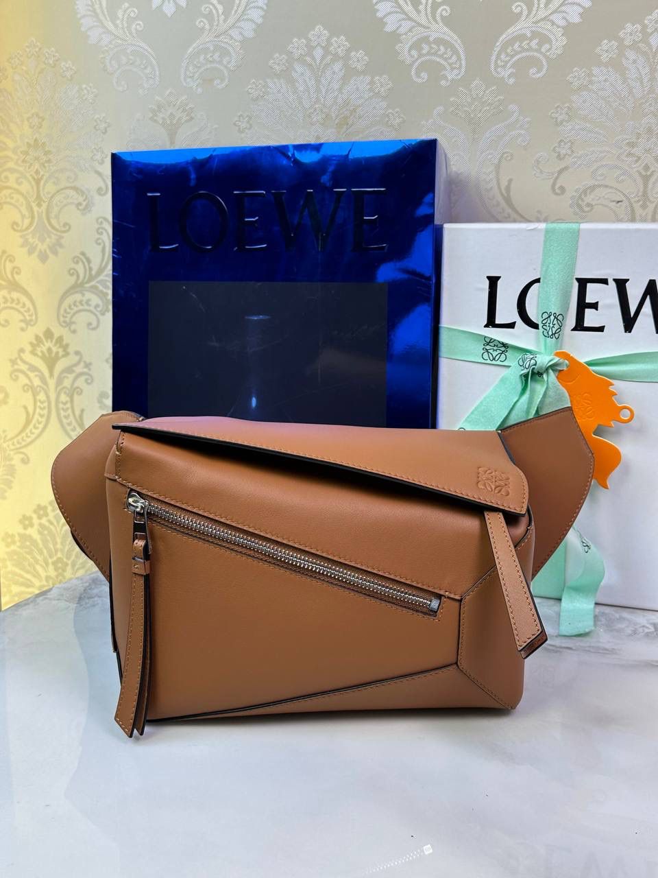 ⭐️最新升级版𝟮.𝟬-𝗣𝘂𝘇𝘇𝗹𝗲腰包⭐️ （土黄到货‼️） 尺寸：𝟮𝟰-𝟭𝟬.𝟱-𝟭𝟲𝗰𝗺 款号：052343 👉🏻长方体形状和精确的切割技巧创造出Puzzle 腰包以及独特的几何线条成为 “Loe罗家”的著名代表作~ 👉🏻金属搭扣开合，刻有标志logo徽标，可调节肩带，翻盖大容量插袋和一个外部拉链口袋，🐂柔软细腻napa小牛皮，正品Ykk五金，Anagram压纹，人字纹棉麻帆布内里 👉🏻（男女♀♂同款）大小非常合适。胸包、背包、单肩、斜挎、腰包五种背法任你解锁🔒 👉🏻 （独家背景➕独家品质➕独家包装➕独家控制对版细节📦➕精致全套礼盒套装❤️） 重点：让你花最少的钱💰体验最大的仪式感❤️