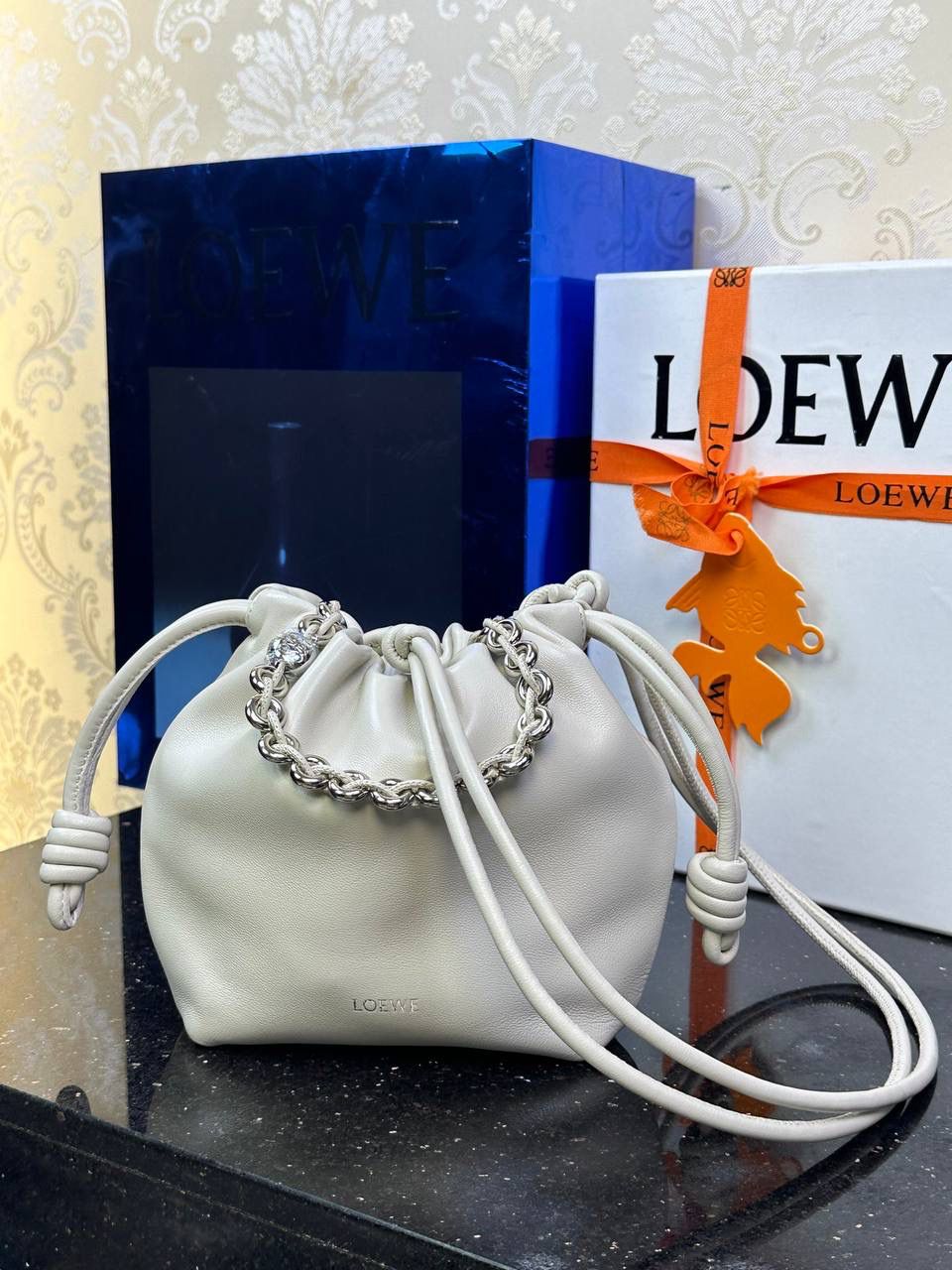 🎈迷你链条款𝙁𝙡𝙖𝙢𝙚𝙣𝙘𝙤 𝙋𝙪𝙧𝙨𝙚羊皮 ——【海盐白】 尺寸：𝟐𝟑.𝟓-𝟓-𝟏𝟕𝐜𝐦 编码：062347 👉🏻延续福袋收缩绳褶皱设计，羊皮包身手感细腻柔软❤️ 👉🏻链条肩带➕皮肩带的双肩带设计，时尚百搭，给足了集美们多样化的选择。肩带可拆卸可调节，磁扣开合，正面烫金𝙇𝙤𝙜𝙤，呈现出高贵典雅的视觉感😍 👉🏻独家背景➕独家品质➕独家全套砖柜礼盒套装，市场高端品质皆在我手✌🏻