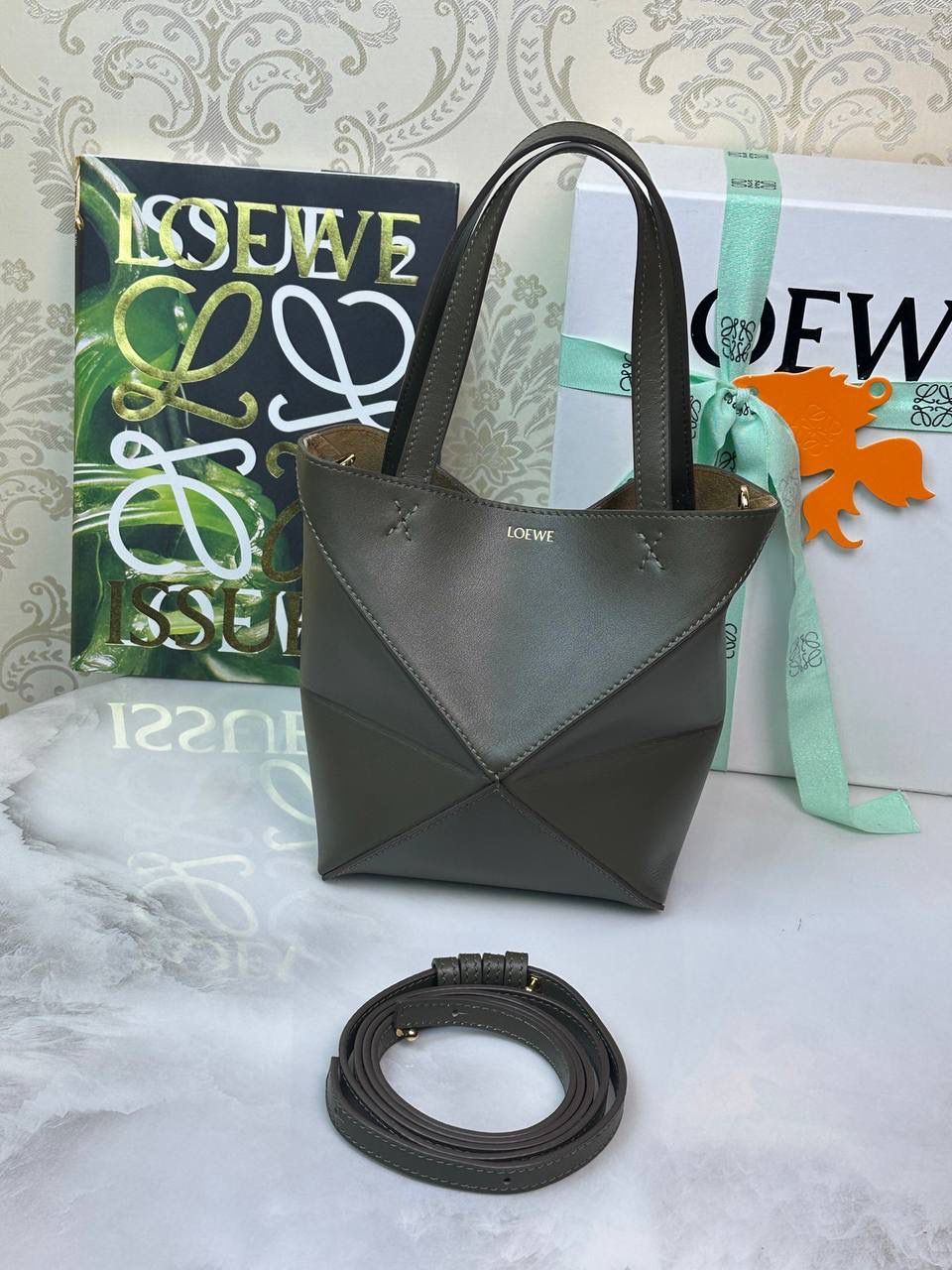 *𝐏𝐮𝐳𝐳𝐥𝐞 𝐅𝐨𝐥𝐝折叠手袋👜* ——全新【𝗡𝗘𝗪】升级‼️ 延续经典𝙋𝙪𝙯𝙯𝙡𝙚的标志性几何裁剪设计，新晋顶流🅰️𝙋𝙪𝙯𝙯𝙡𝙚 𝙁𝙤𝙡𝙚 𝙏𝙤𝙩𝙚以折纸包为灵感，升级成🉑完全折叠‼️的结构，立体与平面任意切换，出差旅行🧳必备单品。小牛皮材质轻且柔软，𝐌𝐢𝐧𝐢尺寸搭配一条可拆卸式肩带，手提，肩背，斜挎多样化背法✨ 尺寸：𝟏𝟔.𝟓-𝟗.𝟓-𝟐𝟎cm 款号：052322