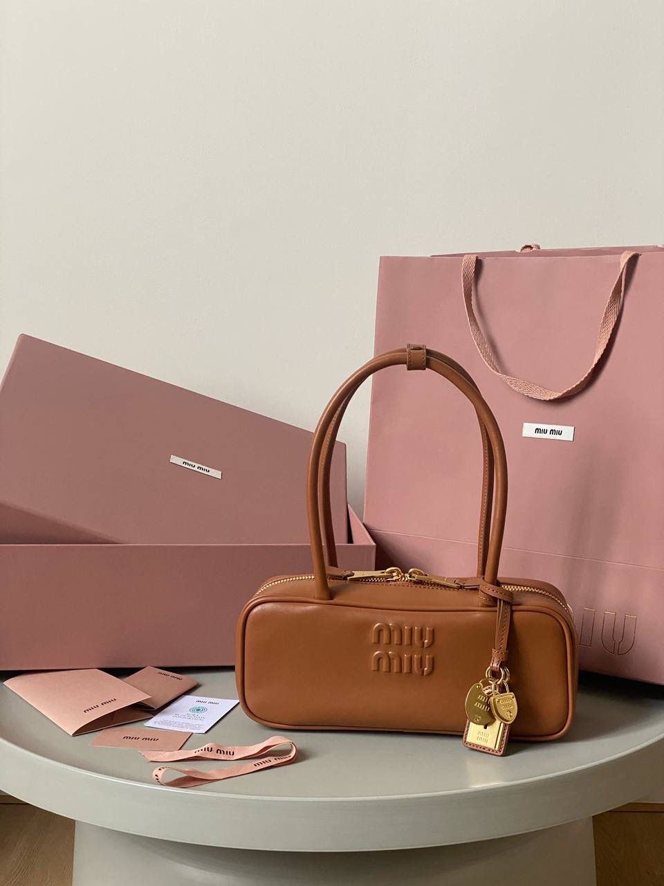 🈶干邑色 𝗠𝗶𝘂𝗠𝗶𝘂保龄球| 吊饰版 说是公文包.更是保龄球！ 虽倆者都早已大火全网时髦圈哈哈 今年这只长手柄保龄球能买到就是赚到咯！ 细长的手柄整体更秀气了 还送了一串吊饰 是一把锁头还有一个爱心， 上面都有logo刻印很精致也很厚重 宝子们再也不愁买挂饰啦！ 28×11.5×8cm #F0010m