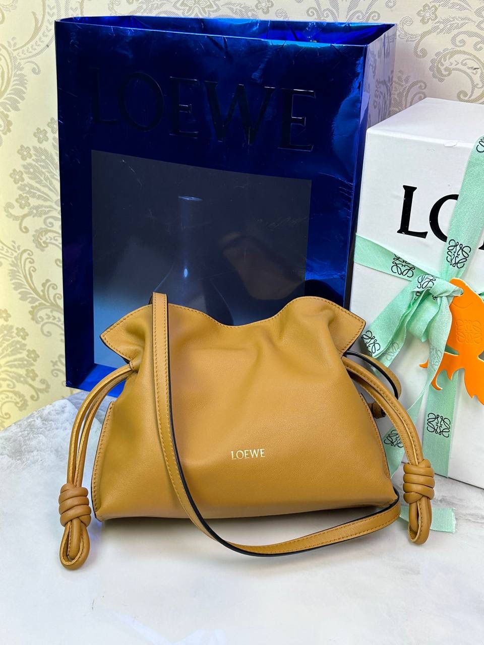 全新升级—中号𝙁𝙡𝙖𝙢𝙚𝙣𝙘𝙤出货啦✅ ❤️升级版福袋正面新增品牌烫金𝙇𝙤𝙜𝙤代替压印𝙇𝙤𝙜𝙤，肩带加宽同时增加两侧狗扣五金代替原本皮穿扣肩带，精致又便捷🥰 ❤️独家定制皮料五金，小牛皮皮质手感十分柔软且耐用，肩带🉑拆卸🉑调节，多种背法任你选择，容量超大，日常出行必备😍 ❤️独家品控，完全对版细节，全套礼盒🎁包装给你满满的仪式感🥰 中号尺寸：𝟑𝟎-𝟏𝟎.𝟓-𝟐𝟒.𝟓𝐜𝐦 款号：052028棕色