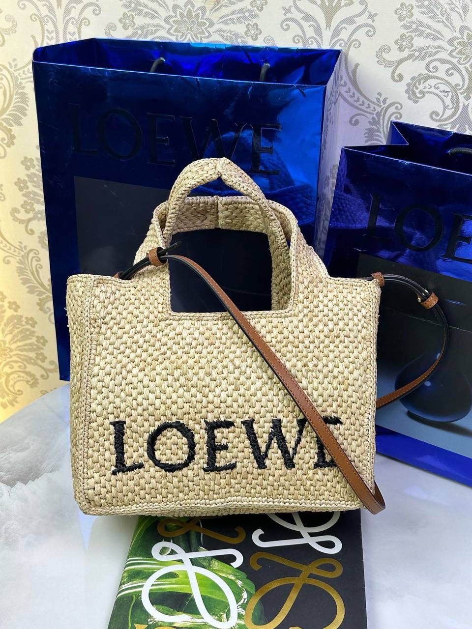 🎈最新𝙇𝙤𝙚𝙬𝙚 𝙁𝙤𝙣𝙩 𝙏𝙤𝙩𝙚 —【小号】酒椰草编包🔔 尺寸：𝟐𝟒-𝟏𝟏-𝟏𝟗.𝟓𝐜𝐦 编码：652207 （下单须知：由于天然纤维材料特别，带毛刺，日照时间长短不同，颜色略有变化，纯手工编织制作而成，每一只都独一无二，每个包的尺寸也有所不同‼️完美主义者慎入⚠️） 👉🏻完全由酒椰纤维编织而成，正面饰有黑色刺绣𝙇𝙊𝙀𝙒𝙀标志 👉🏻肩带可拆卸调节，可肩背、斜挎或手提多种背法