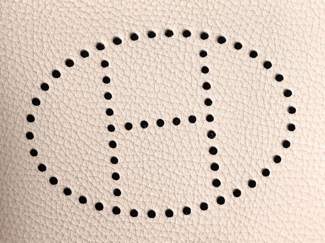 HERMES爱马仕Evelyne 16伊芙琳奶昔白金扣👜✨ TaurillonMaurice 小公牛皮 尺寸：16*18*5cm 爱马仕Evelyne伊芙琳 Evelyne包的设计灵感来自于一种名为“马鞍袋”的马具袋，这是一种常用于骑手和马车夫的袋子，用于储存和运输马具和其他必需品。 爱马仕将这种马具袋的经典元素与品牌的手工艺传统相结合，打造出了具有时尚感和功能性的包包。 因此，伊芙琳包不仅是一款实用的手提包，同时也代表着品牌深厚的历史和文化传统❤️