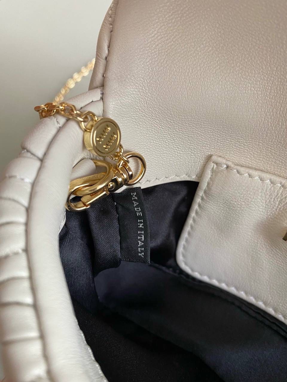 🈶白色 𝗠𝗶𝘂𝗠𝗶𝘂 𝐰𝐨𝐜链条包 咱就是说是不是不止我一个人喜欢这款链条包⛓真的好好看！精致的一塌糊涂，当一只手拿包也能彰显气质 我们用的是进口小羊皮！非国产皮料 肉眼可见的细腻，软软糯糯触感非常好！ 他家经典独特的褶皱工艺，是要有一定厚度 底料太薄了都做不出它的饱满 弹性 更不是市场通货干瘪瘪的褶皱，实在太假 我们新合作的老师傅在这细节上扣的很认真 一缕一折都有zp的神韵，且做到对版！！追求高品质的来 18×9.5×4cm #F0003m