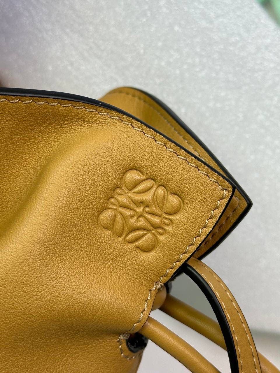 Flamenco clutch ✦迷你✦ 尺寸：𝟐𝟐.𝟓-𝟏𝟖-𝟗𝐜𝐦 型号：052030 棕色 ❤️mini flamenco clutch bag 可手拿亦可优雅斜挎 云朵般温暖亦轻盈的造型如此简单，💯耐看💯不会out的款式！ ❤️包袋采用进口小牛皮，手感如羊皮般细腻柔软，却比羊皮更加结实耐用，麂皮内衬 ❤️品牌标志性绳结设计，收紧袋口就是小福袋造型，超Q，看着不大实际超会装😇