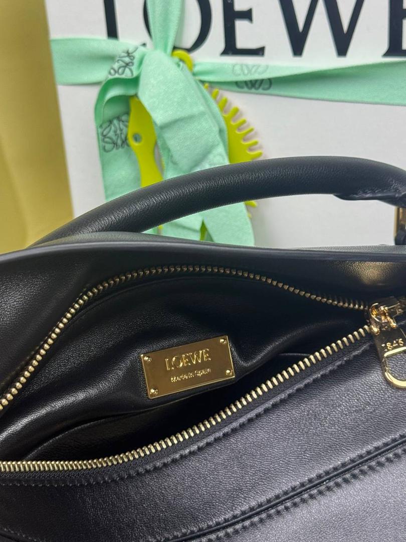 🎈【周年限定】 小号纳帕羊皮𝗙𝗲𝗮𝘁𝗵𝗲𝗿𝗹𝗶𝗴𝗵𝘁 𝗣𝘂𝘇𝘇𝗹𝗲手袋👜 ——黑色到货❤️ 尺寸：𝟮𝟰-𝟭𝟬.𝟱-𝟭𝟲.𝟱𝗰𝗺 编码：061610【配全套礼盒】 ✅延续经典老款𝗣𝘂𝘇𝘇𝗹𝗲做法，全新𝗣𝘂𝘇𝘇𝗹𝗲内外采用柔软轻盈的纳帕羊皮材质，为手袋注入随性慵懒的风格。 ✅该款饰有旋转卡扣，铰链式拉链头，一个外部拉链后袋，一个内部插袋，以及可拆卸式的𝗟𝗢𝗘𝗪𝗘烫金或烫银标签，饰有隐秘口袋和气球骰子，底部长方形金属脚钉。搭配可拆卸可调节长肩带，可肩背、斜挎或手提。