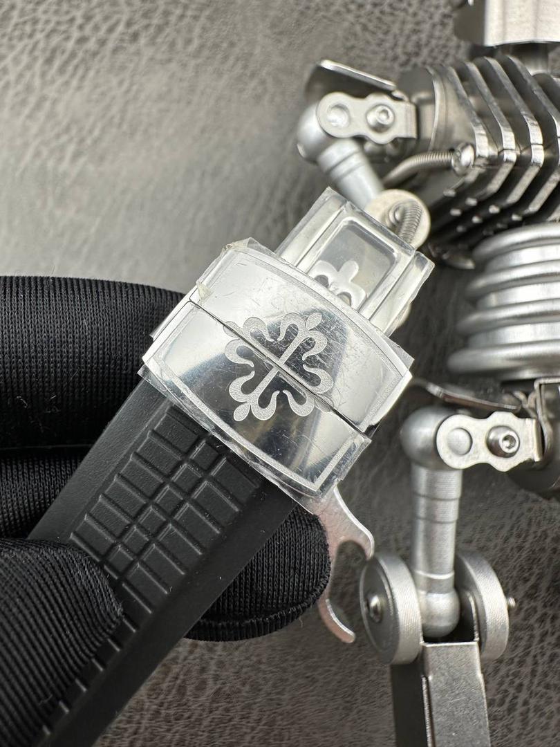 百达翡丽Aquanaut系列😎 【表壳】40.8MM表径，不锈钢材质，圆润的八角壳型恰到好处，表壳左侧的鲨鱼鳍型设计，是可以前后快调中央镂空时针的按钮，这枚指针可以用来指示第二时区时间。 【表盘】黑色浮雕表盘，金属立体字块，覆荧光涂层时标。3、9点钟分别显示”HOME”与”LOCAL”的方形昼夜视窗，蓝白二色各自代表晚上与白天，6点钟位置是指针式的日期盘。 【机芯】成功实现百达翡丽5164A-001内载的324 SC FUS自动上链机芯功能，大三针基础机芯上搭载两地时间模组。 配有休闲气息的Tropical表带，正是为年轻世代所准备的奢华运动表。