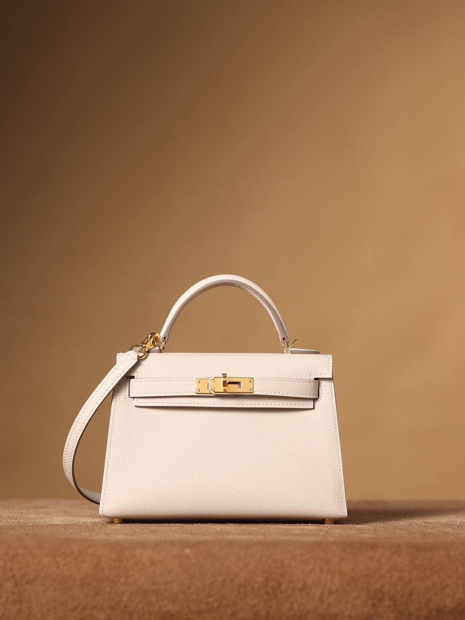 HERMES 爱马仕 Mini Kelly 二代 👜✨ Mini Kelly 二代 奶昔白金扣 高清实拍图 尺寸：19*12*6cm Hermès爱马仕是世界著名的奢侈品品牌，1837年由Thierry Hermès创立于法国巴黎。爱马仕早年以制造高级马具起家，迄今已有180年的悠久历史。 其整个品牌从整体到细节以及专卖店，都弥漫着浓郁的以马文化为中心的深厚底蕴🎀