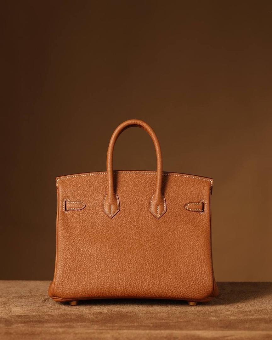 Hermes 爱马仕 Birkin25cm 金棕金扣👜✨ Birkin 独家渠道货 独家欧洲原厂皮原厂五金组装的ZP尾单货 尺寸：20 X 25 X 13CM 尺寸：22 X 30 X 16CM Birkin我们采用的是进口原厂Togo真皮，什么是Togo皮呢？ Togo皮：最经典的Birkin用皮。表面是均匀的颗粒状，类似荔枝纹，有光泽。皮质较硬，容易保持包包的形状，相对较轻，触感比较柔软，耐磨耐用； 我们用的是纯原、原厂皮就是和原版专柜一样的皮！