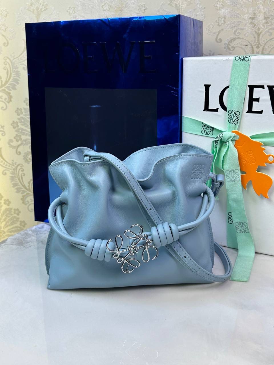 Flamenco clutch-NEW ✦迷你✦ 尺寸：𝟐𝟐.𝟓-𝟏𝟖-𝟗𝐜𝐦 型号：052030灰蓝色 ❤️mini flamenco clutch bag 可手拿亦可优雅斜挎 云朵般温暖亦轻盈的造型如此简单，💯耐看💯不会out的款式！ ❤️包袋采用进口小牛皮，手感如羊皮般细腻柔软，却比羊皮更加结实耐用，麂皮内衬 ❤️品牌标志性绳结设计，收紧袋口就是小福袋造型，超Q，看着不大实际超会装😇